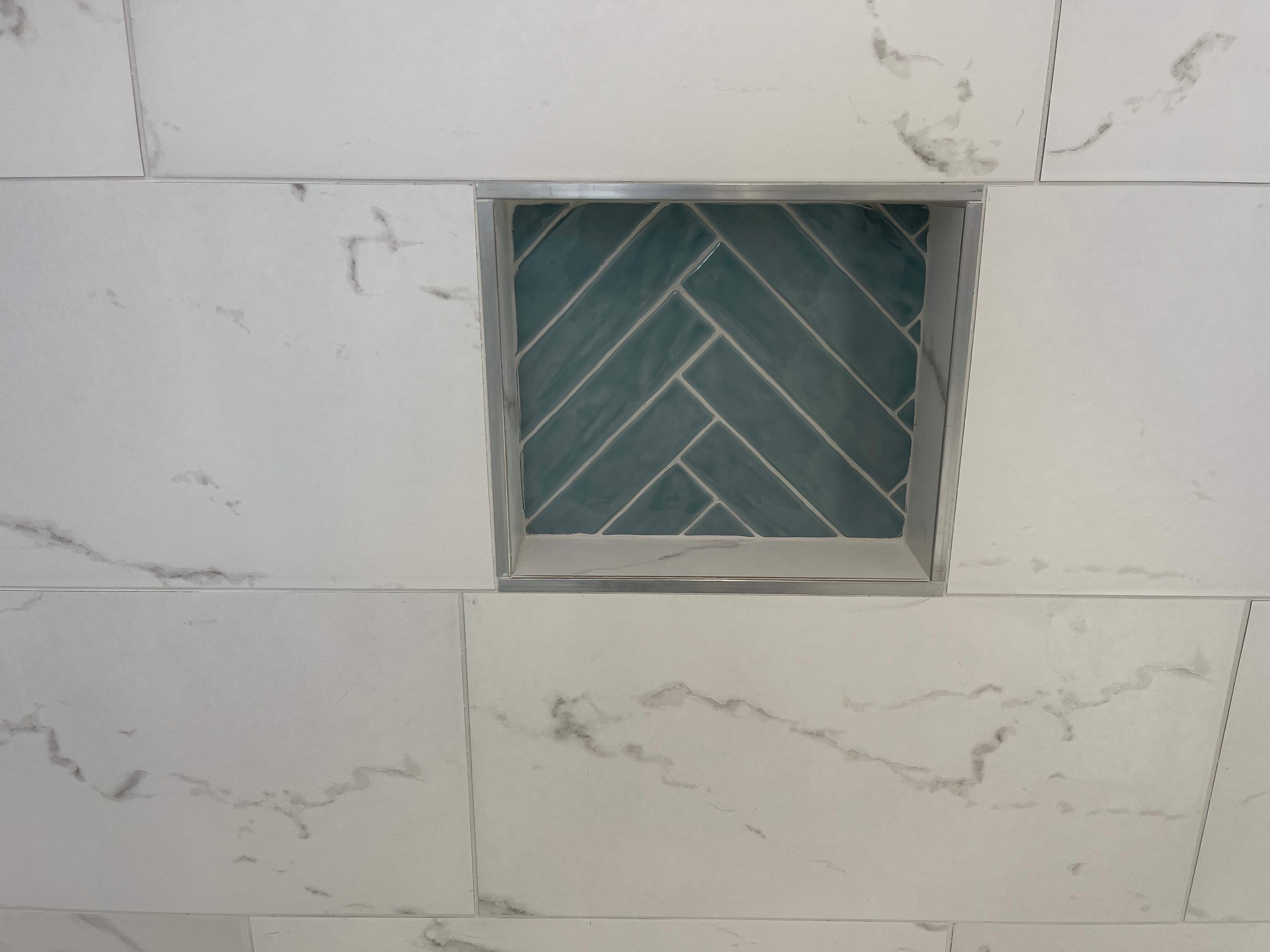 Complete Bathroom Remodel Featuring Marble Tile and Teal Herringbone Niche by Mena stone surfaces