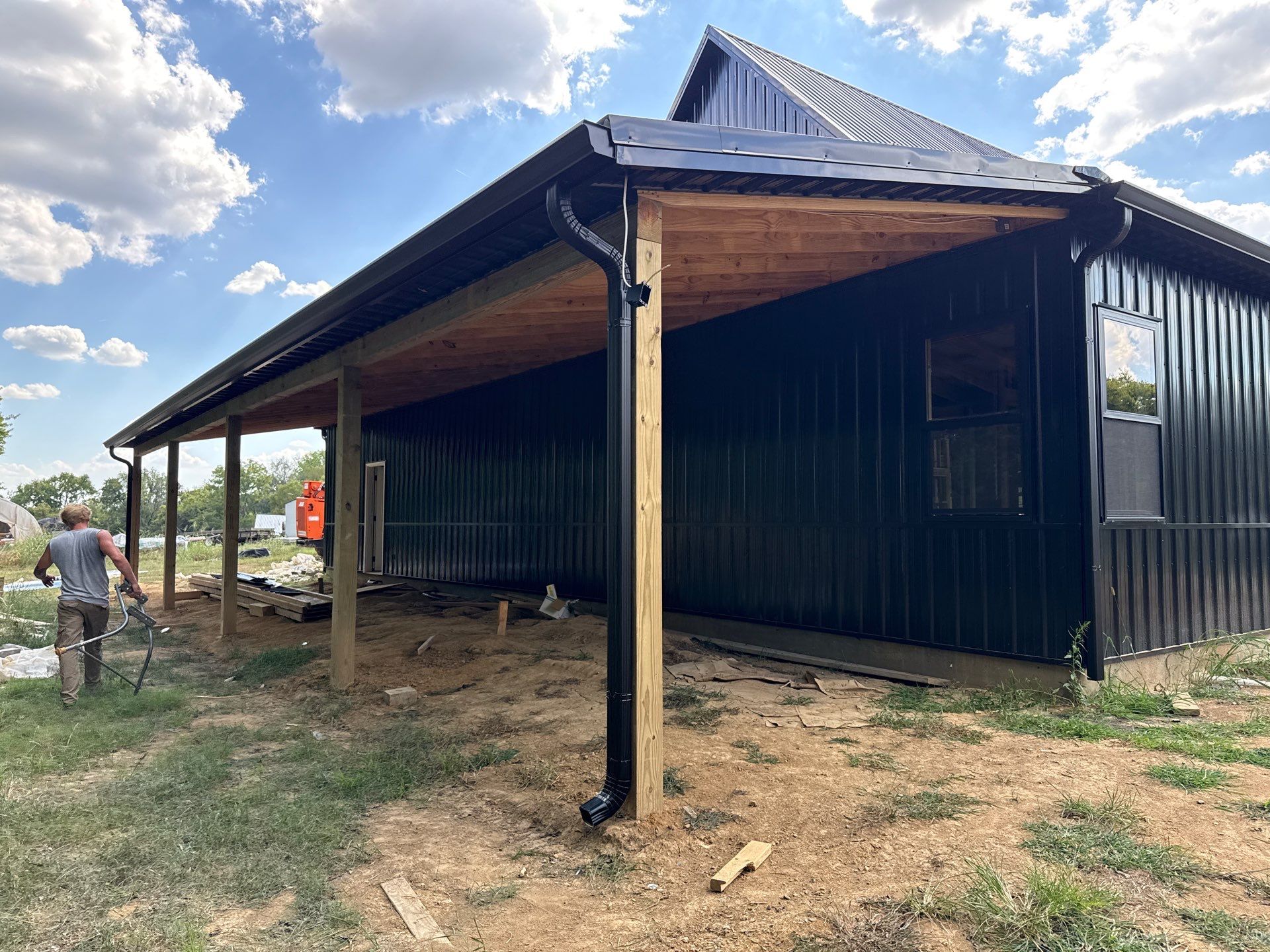 Black gutters on black building  by First Choice Gutters LLC