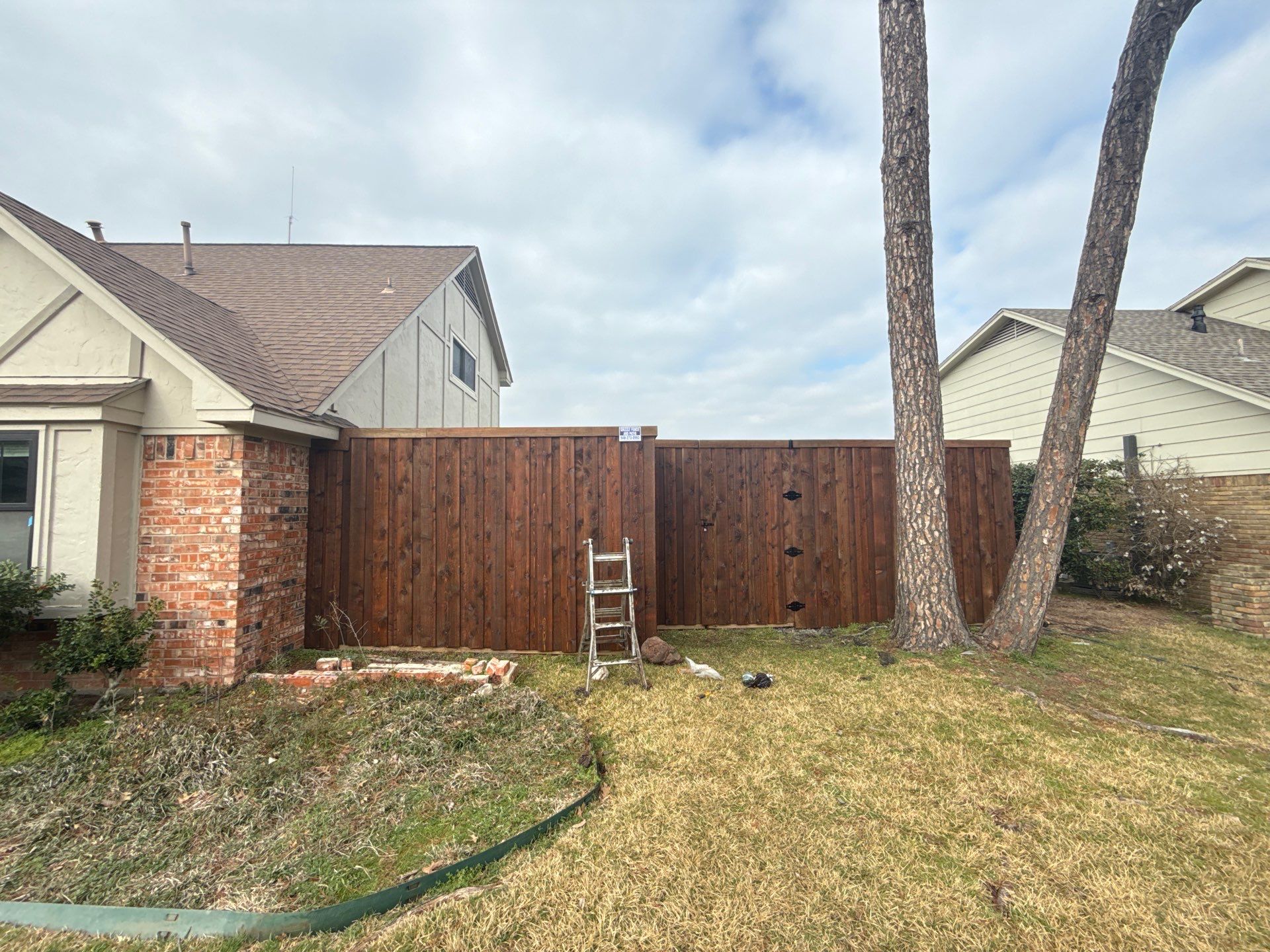 Pre-Stained board on board w/ trim and kickboard using 1x4 cedar trim by Grizzly Fence And Patio
