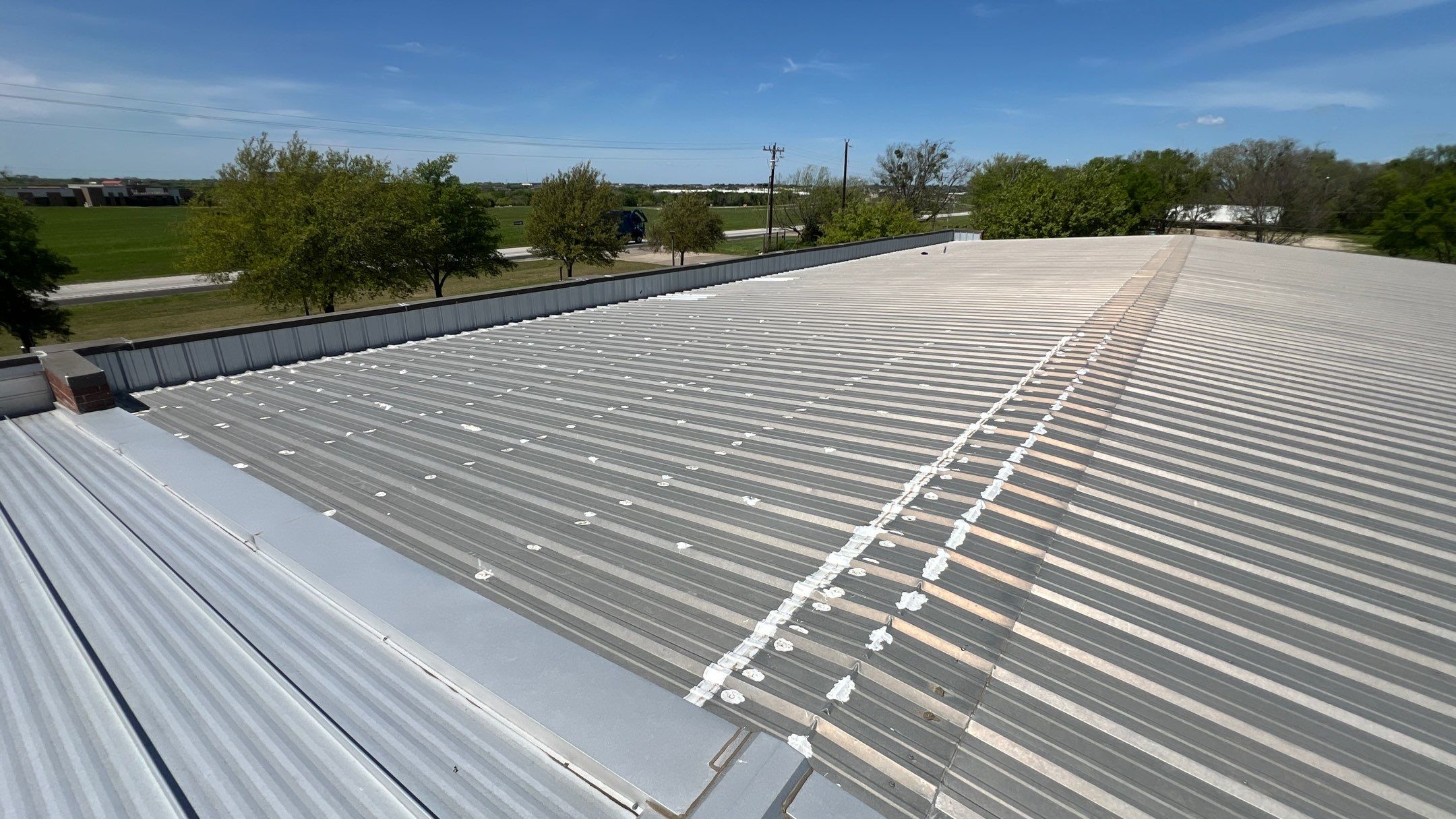 Commercial Roofing Installation using TRP #924 Eterna-Sil Premium Silicone Roof Coating by Harvey Roofing & Construction