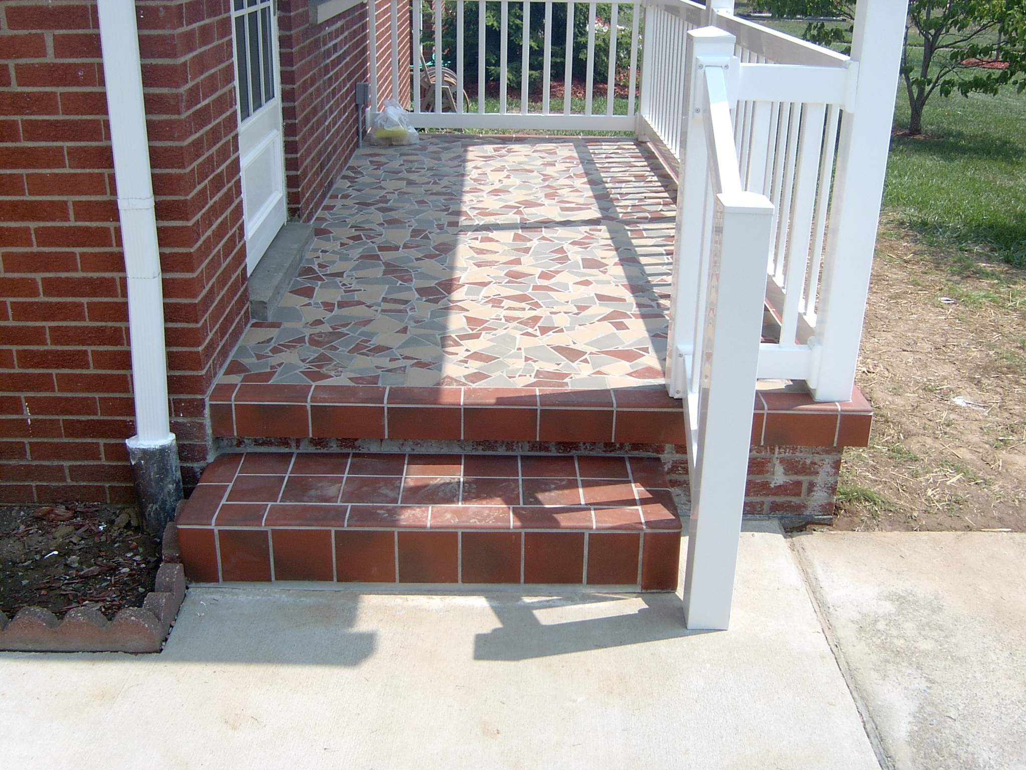 New front porch build, with tile floor and vinyl railing. by Secure Construction Company Inc