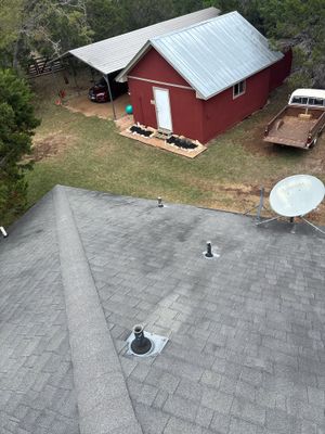 Asphalt shingle roof with a metal roof shed nearby.