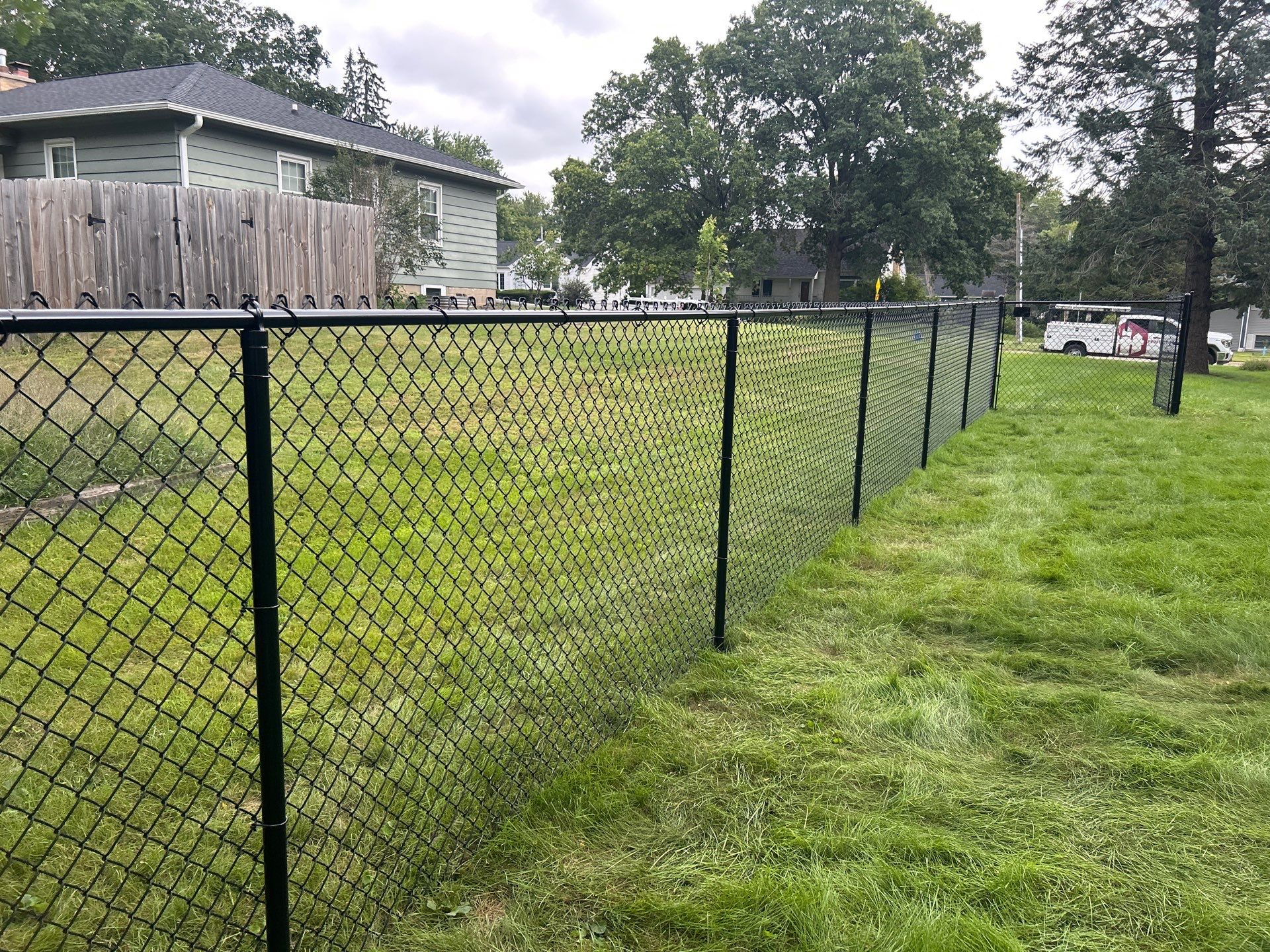 Black Vinyl Coated Chain Link Fence Installation in Waterloo by Perfect Picket Fence and Stain