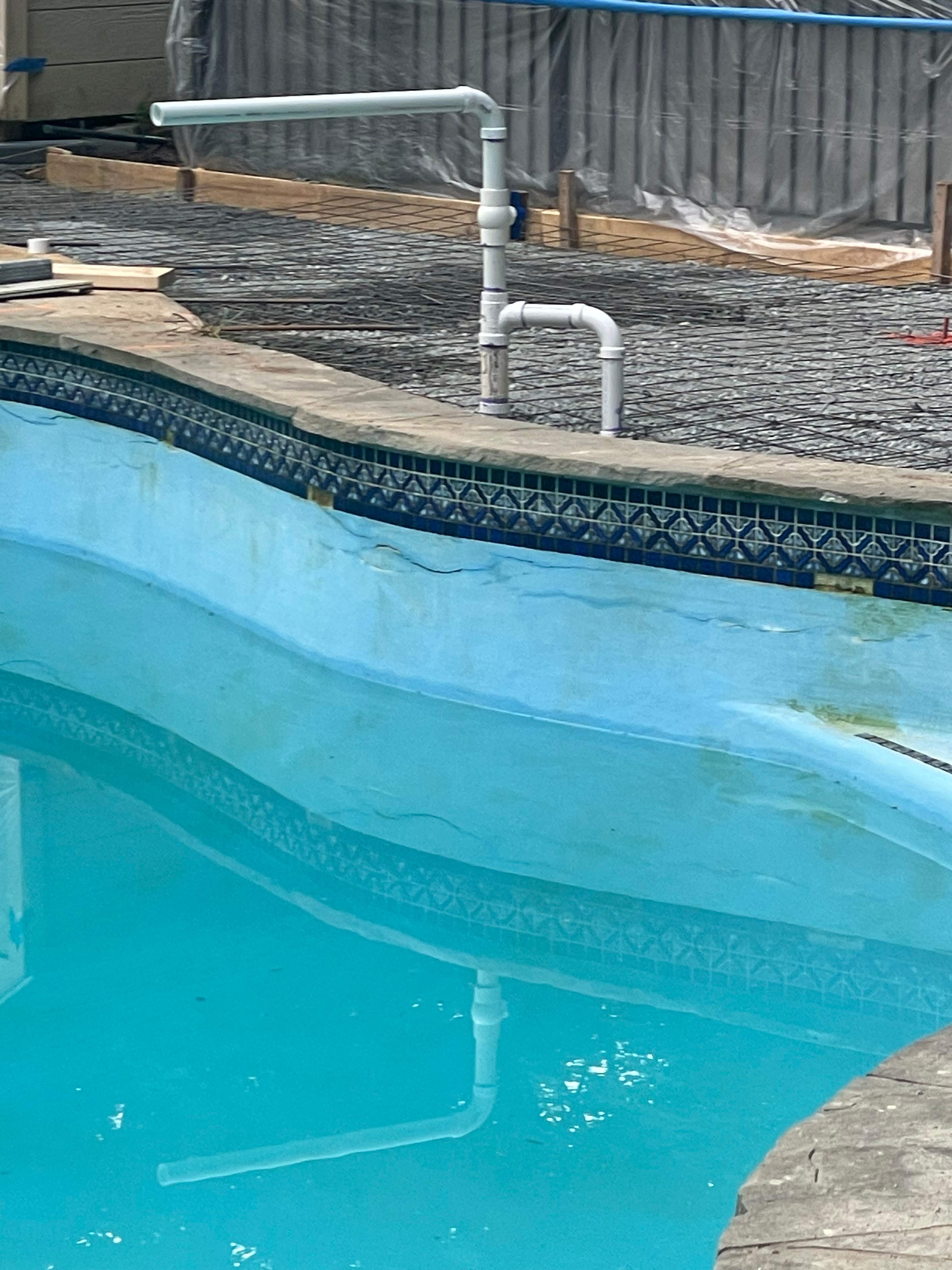 Pool Surround remodel with retaining walls, new waterfall and water slide by Fairfax Contractors, LLC