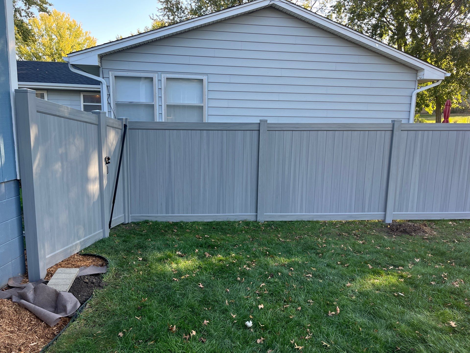 Chai Gray Vinyl Privacy Fence and Gate Installation in Cedar Falls by Perfect Picket Fence and Stain