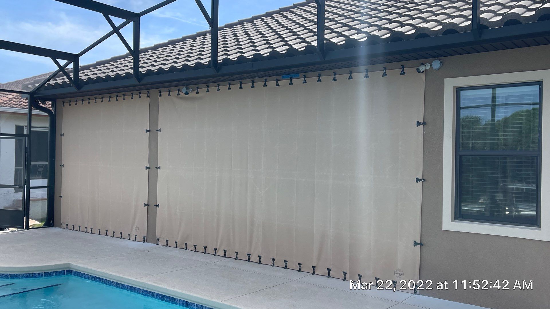 Bronze rolling screen with hurricane fabric by Smart Guard Shutters