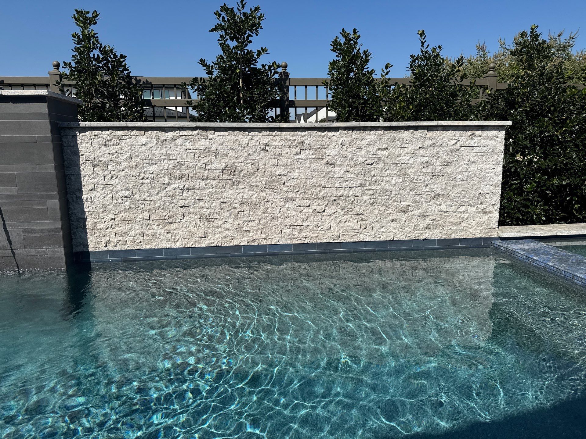 Geometric Pool with Raised Stone Scupper Wall and Outdoor Kitchen by Pinnacle Pools and Spas - DFW