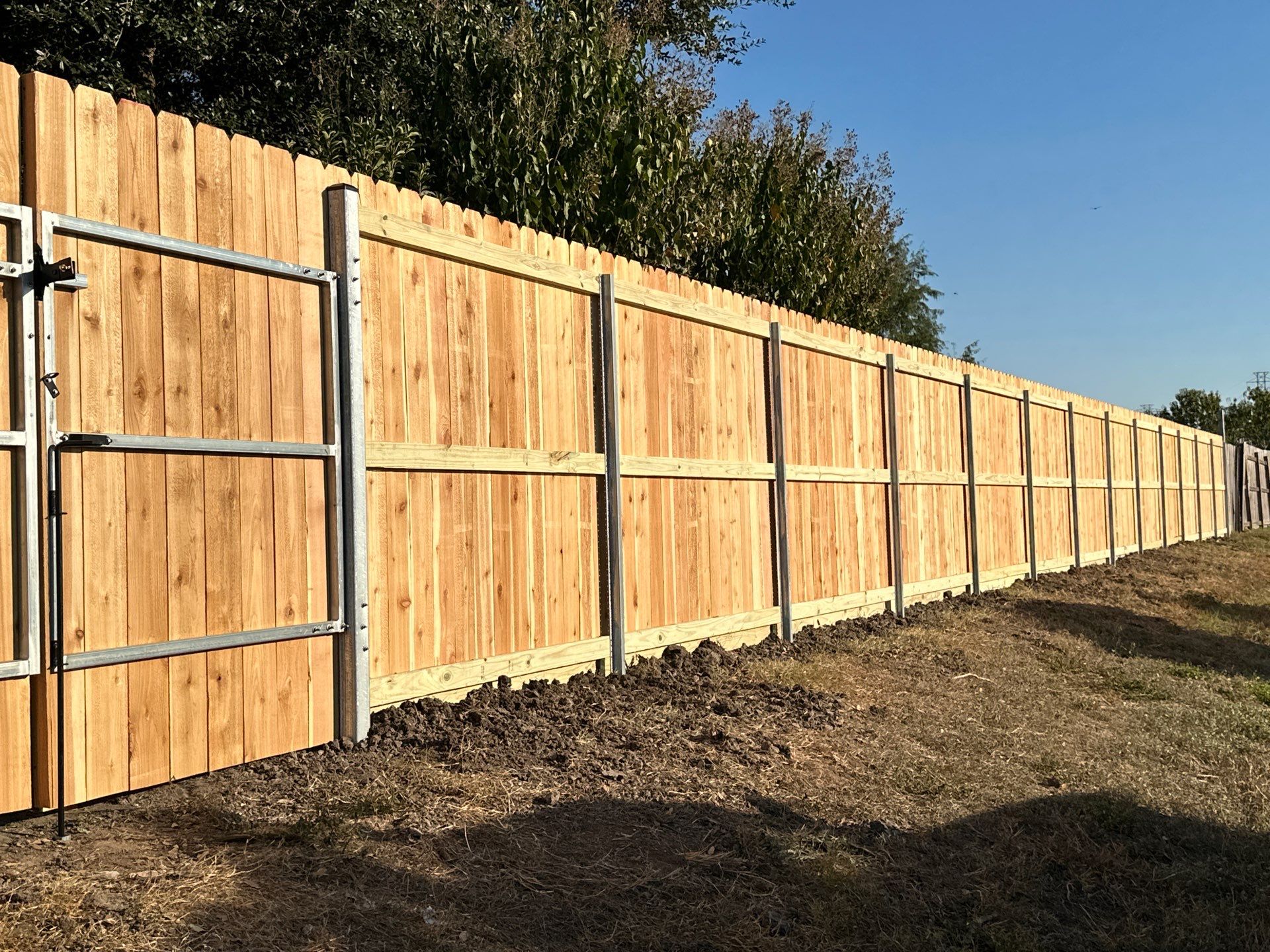 Beautiful Wood fence with metal posts by Tim's Fences