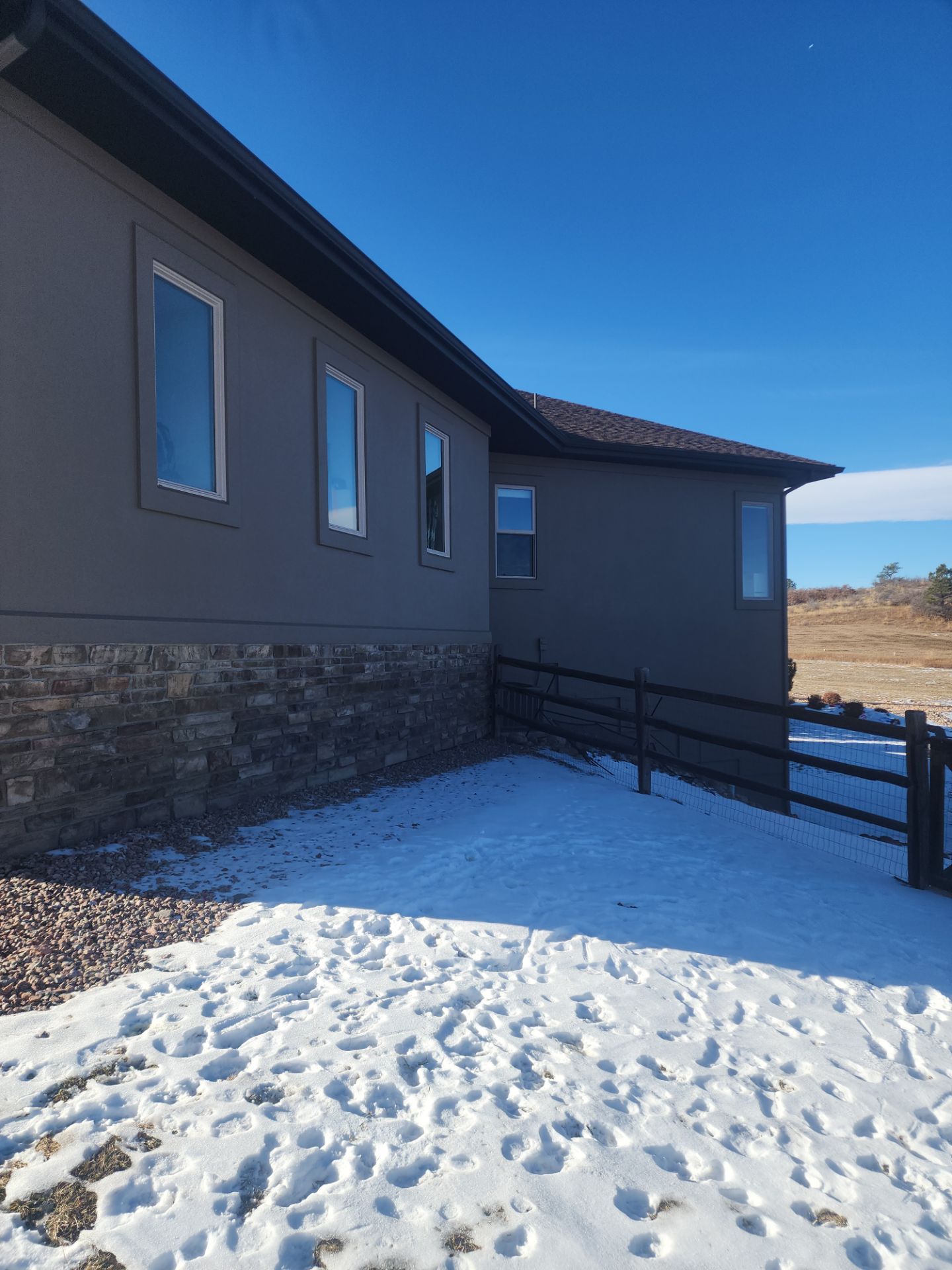 Castle Rock Elegance: White Stucco Exterior with Bold Tricorn Black by J&M Painting LLC