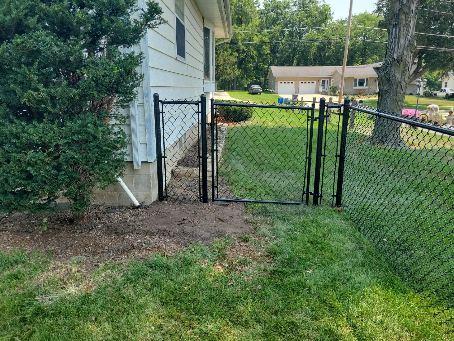 Black Vinyl-Coated Chain Link Fence Installation in New Hampton by Perfect Picket Fence and Stain