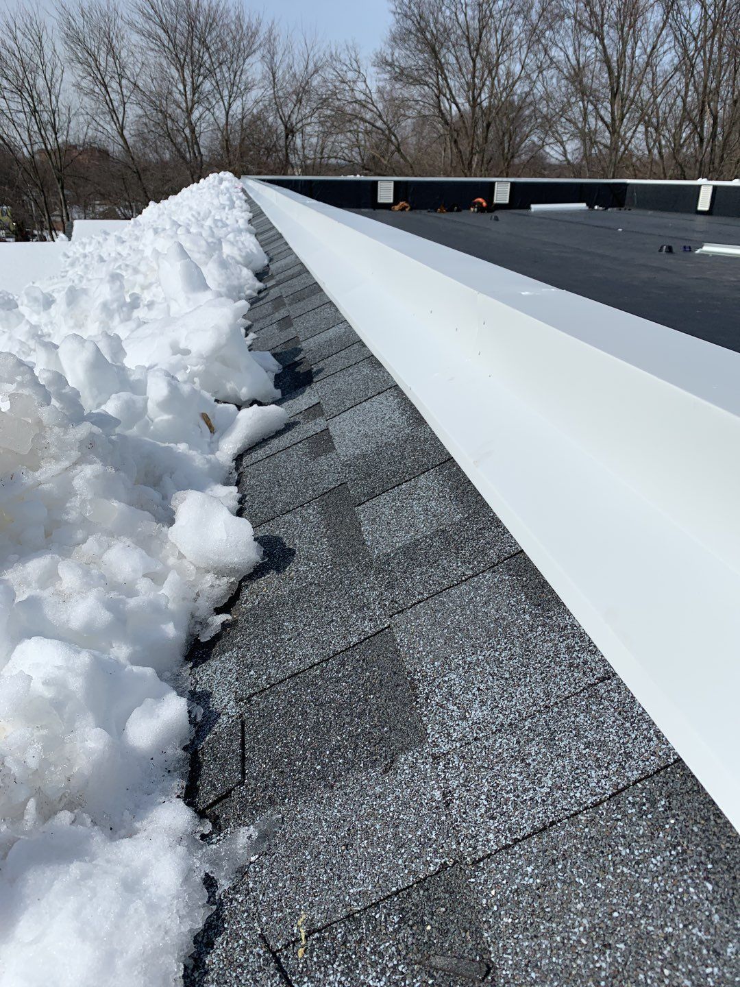 Commercial Roofing Installation using EPDM with white gutters by A Plus Exterior
