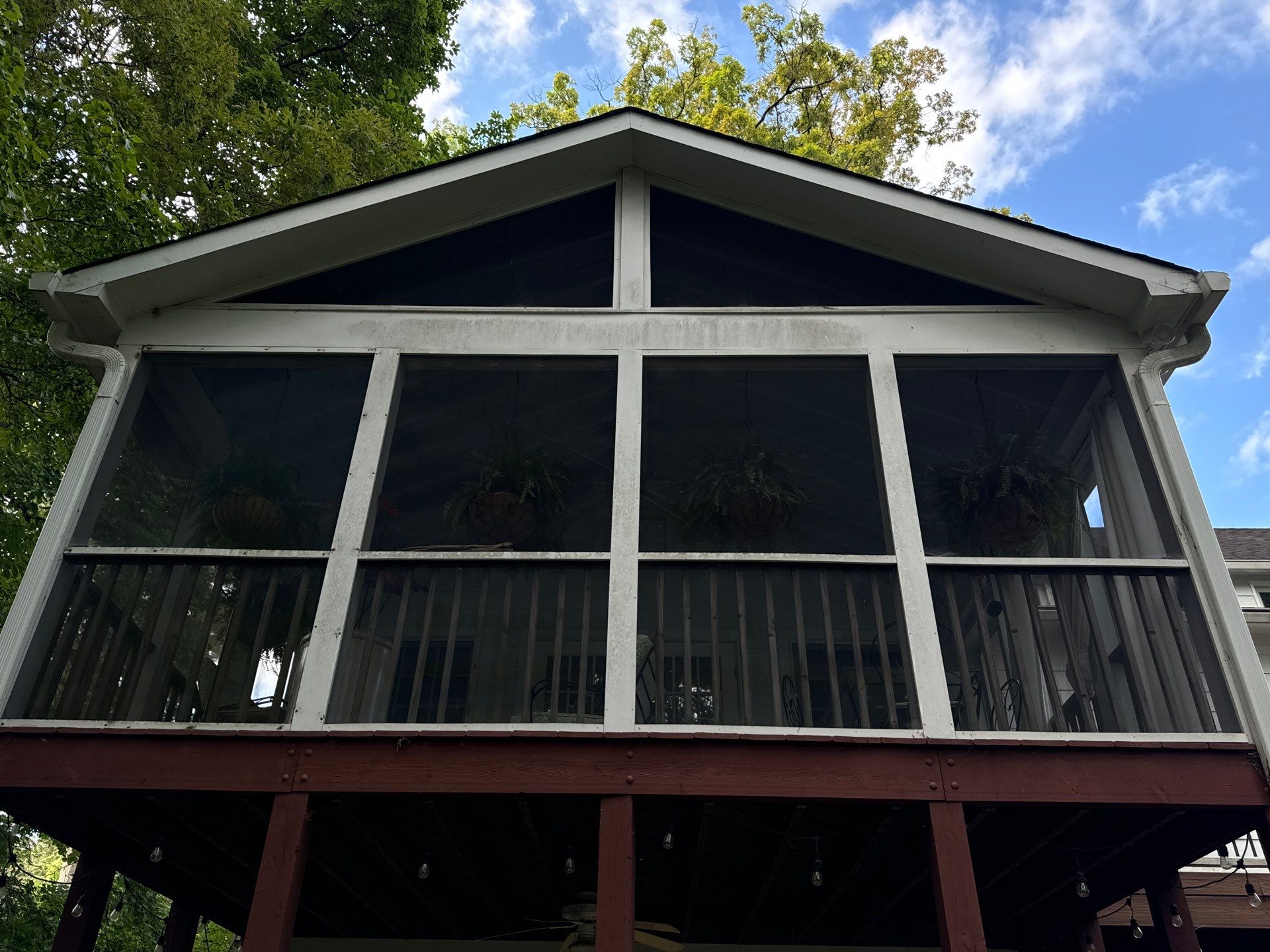 pressure washing company cleaning a second story porch with screens railings and siding in winston salem nc