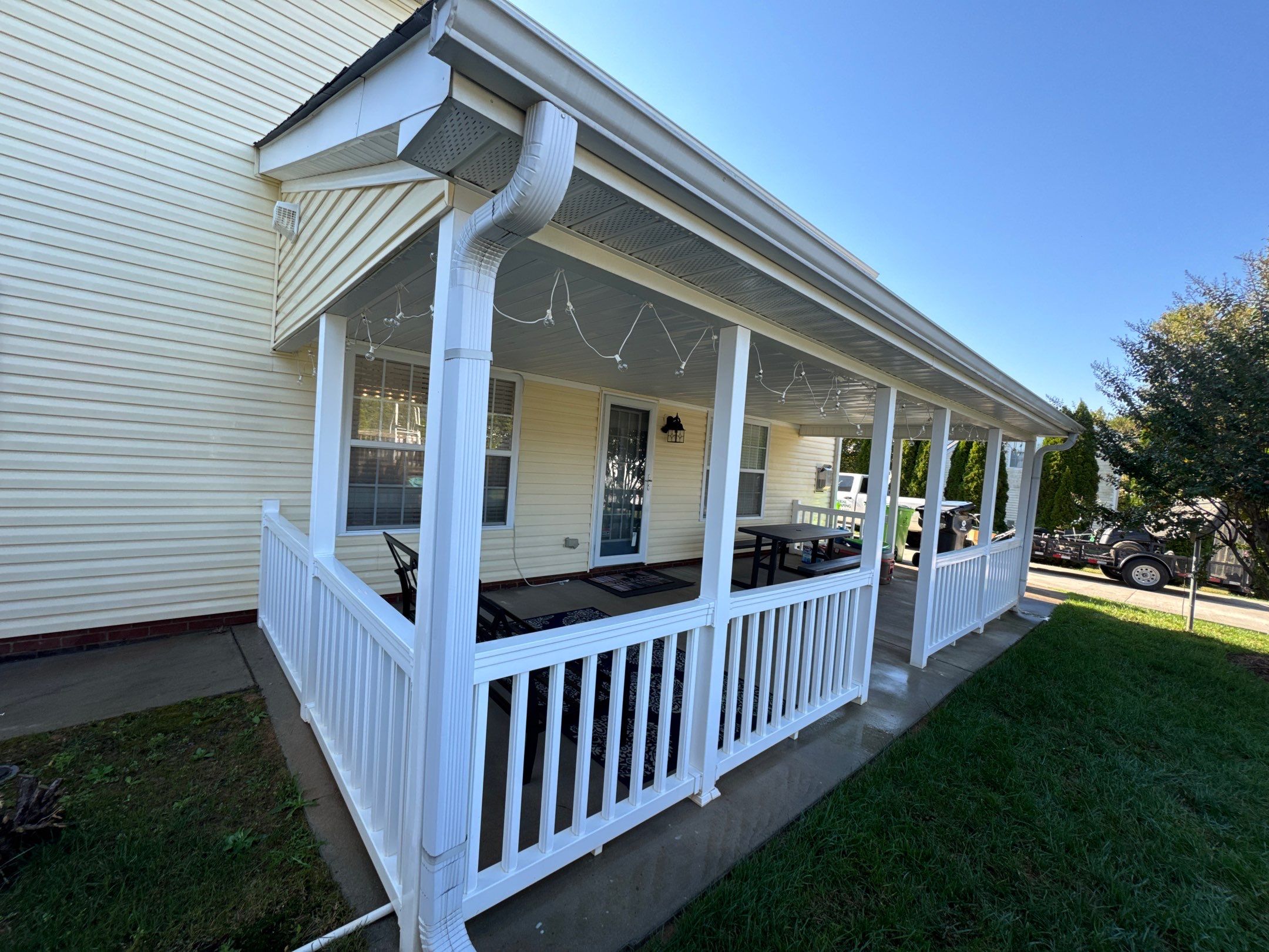 the service being done is cleaning the patio and siding surfaces to remove dirt and grime for a refreshed appearance