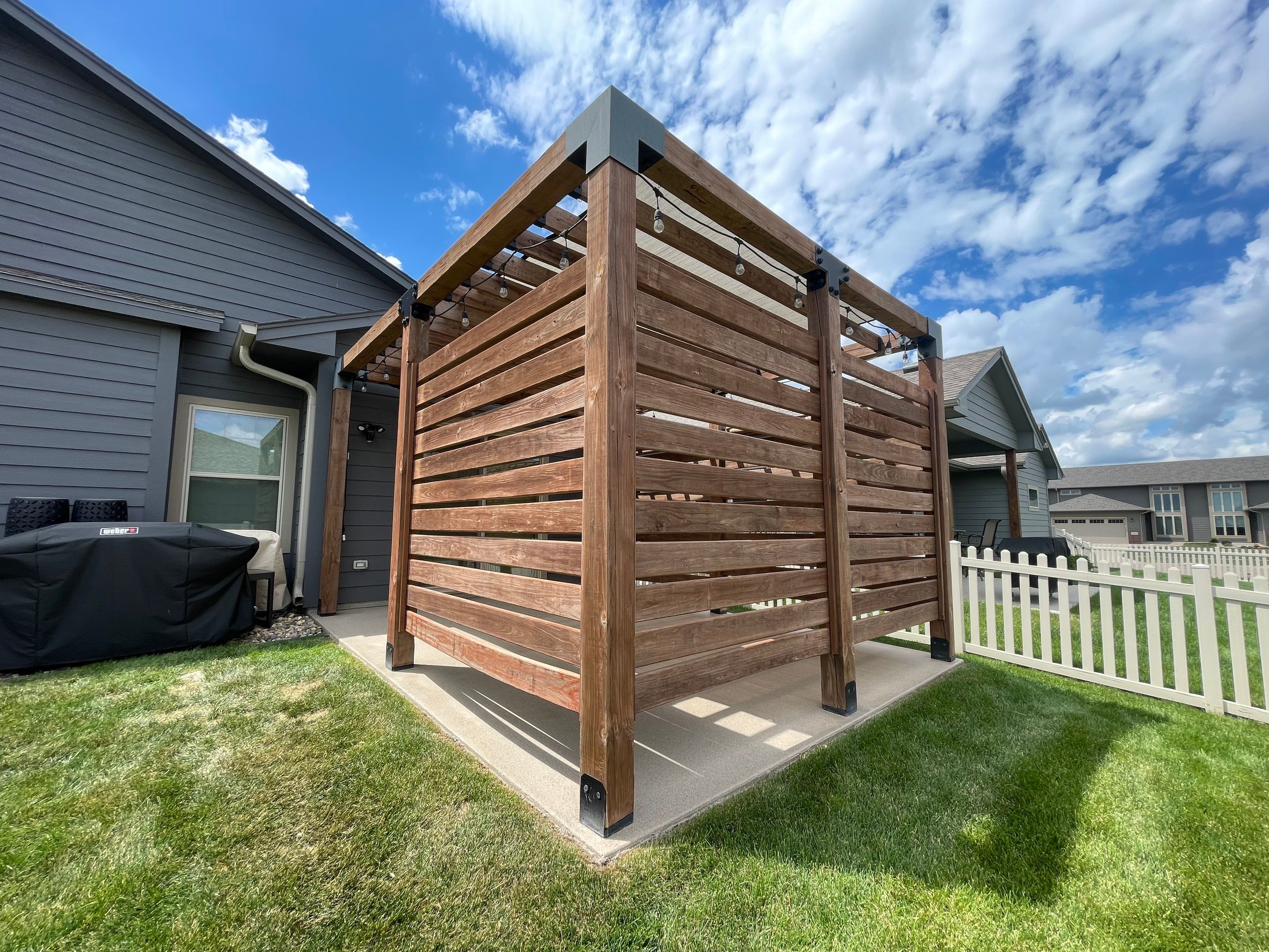 Textured Concrete Patio Coating and Custom Privacy Pergola in Sioux Falls by Select Painting, Coatings & Garage Cabinets