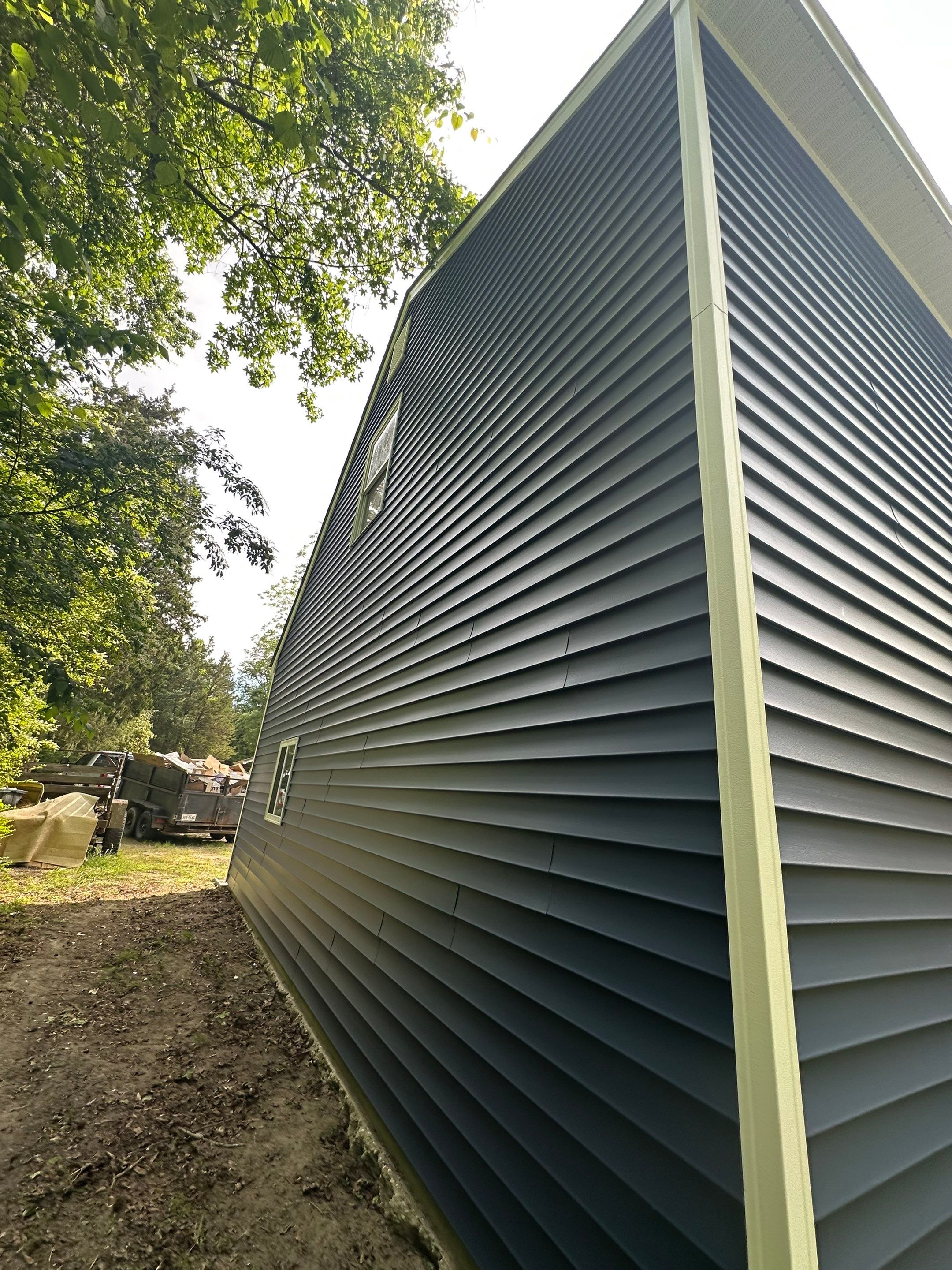 Gloucester Exterior Overhaul with Navy Blue Siding and New Roof by Cade Construction