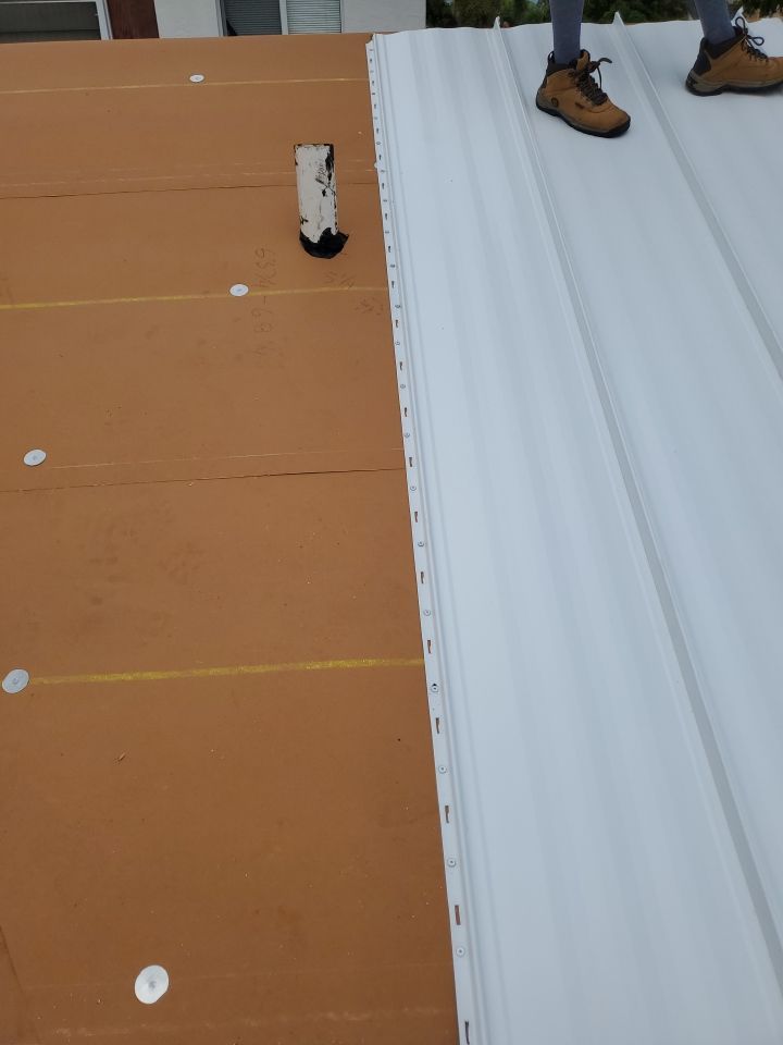 Residential Roofing Installation using 1.5" Nail Strip 24ga Solar White Kynar Coated Standing Seam Metal Panels by Morton Roofing, Inc.