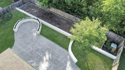 Major Transformation Project: Retaining Wall, Patio, and Drainage for Mr. & Mrs. Veerman! 🤩🛠️ We recently completed a comprehensive, custom project for Mr. & Mrs. Veerman that was all about structure, stability, and stunning outdoor design! This was a multi-phased project requiring the expertise of our Master Handcrafted Team.  Phase 1: Foundation and Water Management A successful outdoor space starts beneath the surface. We focused heavily on preparation and protection:  Demolition & Grading: We professionally removed and disposed of old dirt to achieve a level surface, ensuring the entire area was leveled and graded to enhance both appearance and functionality.  Comprehensive Drainage System: To prevent water issues and protect the new construction, we installed a complete system, connecting existing downspout gutters to channel drainage and strategically placed catch basins around the patio area.  Robust Concrete Foundation: Expert framing led to the pouring of a 4-inch deep, high PSI concrete slab to create a robust and lasting foundation for the entire retaining wall area.  Phase 2: Handcrafted Structure and Style This phase brought in our masonry and carpentry artisans to build the defining elements of the new space:  Custom Retaining Wall: Our master handcrafted team built a stunning, structural retaining wall. This involved careful framing, precise concrete work, and meticulous masonry construction with vertical supports every 3 feet for maximum stability.  Client Involvement: Mr. & Mrs. Veerman played a key role in selecting the retainer wall fascia and stone materials, ensuring the final look perfectly matched their vision.  Stamped Concrete Patio: We installed a beautiful stamped concrete patio. This decorative concrete work involved imprinting a pattern into the fresh concrete, giving them the high-end look of stone or brick with the durability of concrete.  Walk Add-On: Extended the stamped concrete to include a new, seamless walk area.  (Optional) Custom Garden Box: Constructed durable, raised garden boxes using 2"x12" boards and strong 4"x6" posts.  Phase 3: Landscaping and Finishing Touches The final details bring the entire project to life, focusing on irrigation and planting:  Sprinkler System Upgrade: To support their new landscaping, we upgraded their irrigation system by installing two new drip zones and a new control unit.  Flower Beds: Integrated new flower beds along the retaining wall and patio, ready for planting.  Decoration: Concluded the project with personalized decoration options to perfectly complement their beautiful, newly structured space.  Thinking About a Multi-Layered Outdoor Project? This project demonstrates our ability to seamlessly handle complex jobs—from heavy-duty drainage and structural construction to decorative finishes and irrigation.  The proposed timeline for this extensive project was 10 to 15 working days!  ❓ Do you have a sloping yard or drainage issues that could be solved with a functional and beautiful retaining wall? Tell us your challenge! 👇  💡 We specialize in bringing intricate outdoor visions to life! If you're looking for a team with master craftsmen for your next patio, retaining wall, or full landscape overhaul, let's talk.