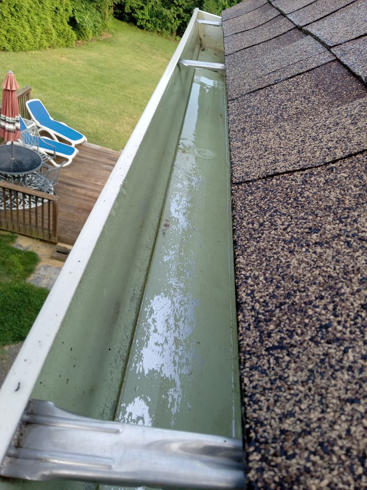 pressure washing company cleaning a gutter and roof removing debris and dirt buildup