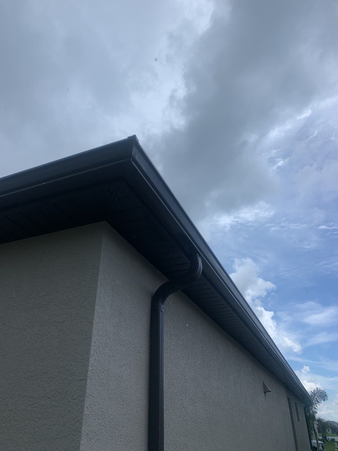 Seamless brown gutter and downspouts installation in Estero, FL  by Gutter Professors