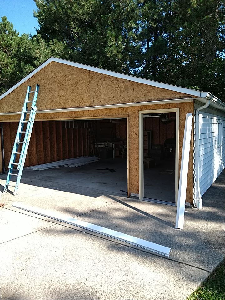 Siding Installation using Norandex woodsman dl-5 white woodgrain vinyl by Absolute Roofing and Construction