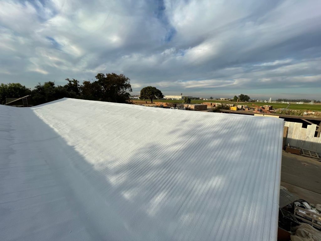 Metal roof sprayed with polyurethane spray foam and coatings by Straight Edge Roofing Inc