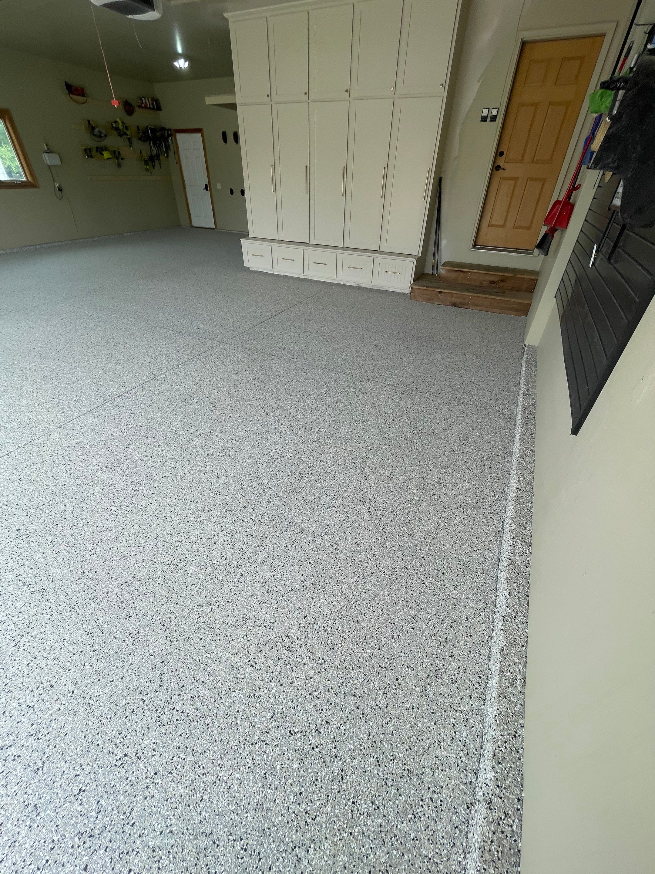 Cabin FEver Flake Garage Floor Coating Installation in Sioux Falls by Select Painting, Coatings & Garage Cabinets