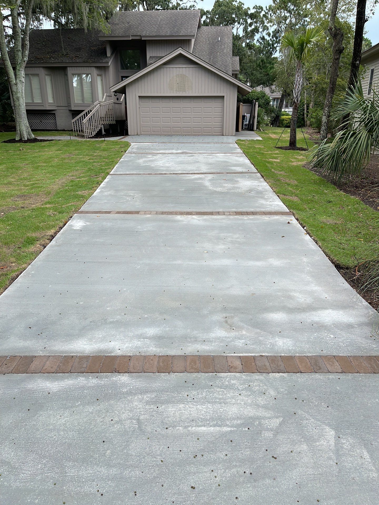 Concrete Driveway Replacement with Brick Paver Accents in Hilton Head Island by Lowcountry Scapes, LLC