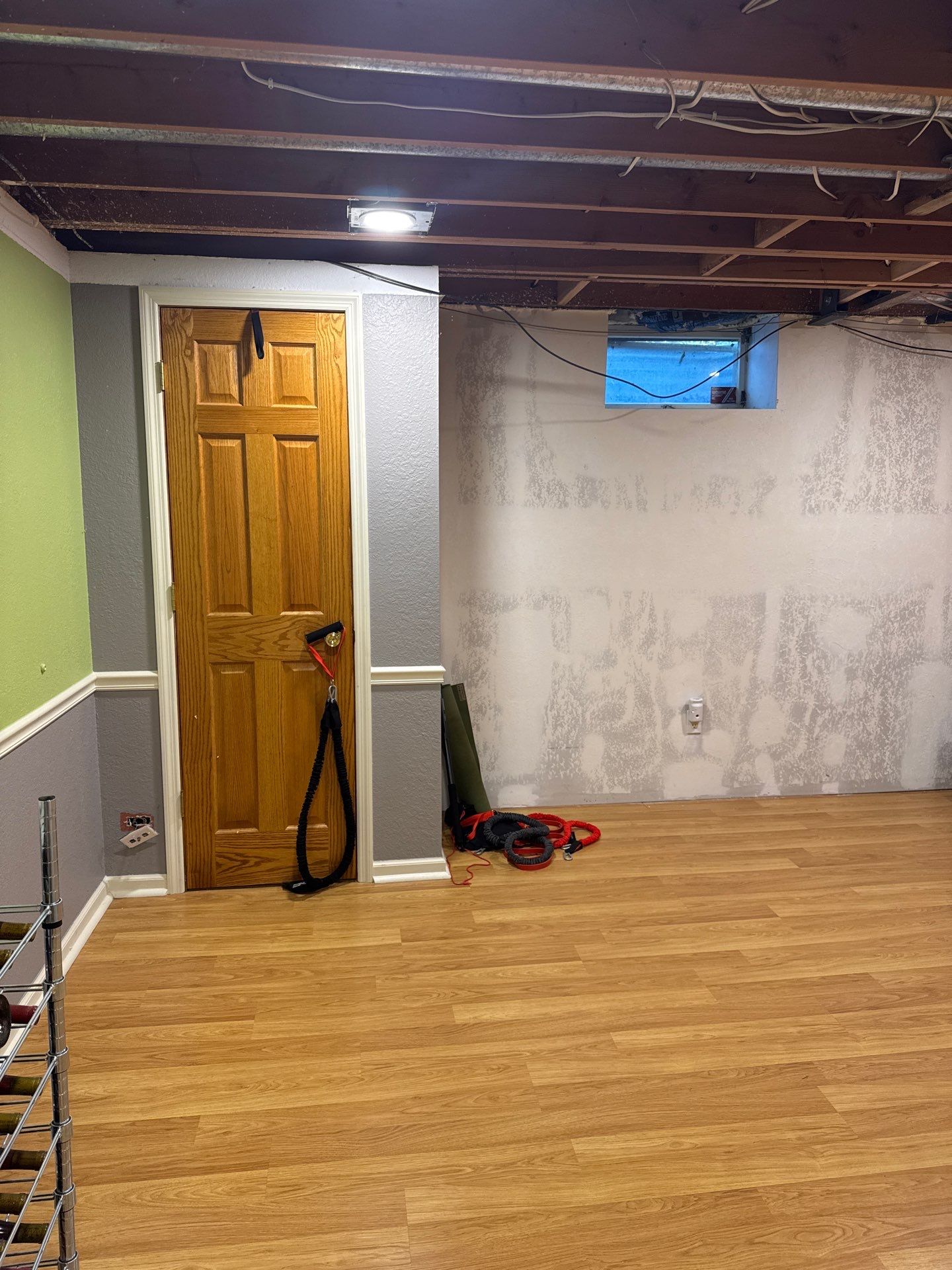 Basement Remodel with Exposed Painted Ceilings and Laminate Flooring in Mequon by OCS Contracting Services