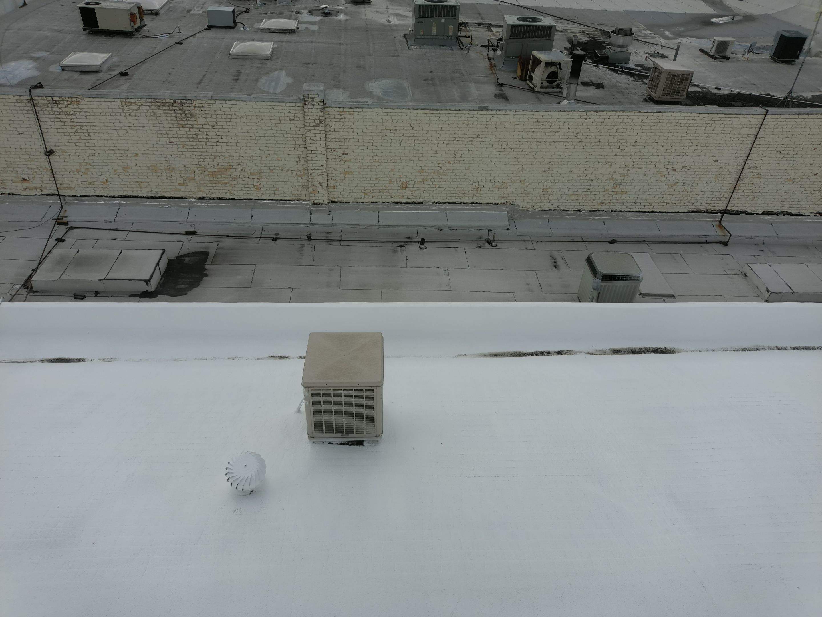 Foam and coatings on commercial roof by Straight Edge Roofing Inc