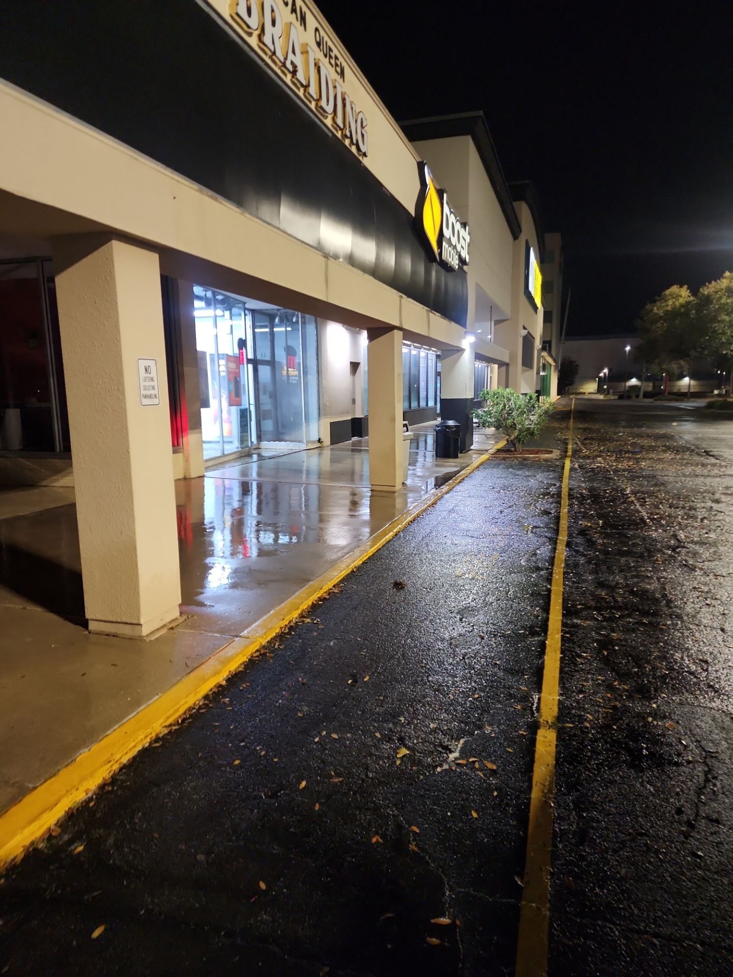 Sidewalk concrete asphalt building exterior columns after pressure washing