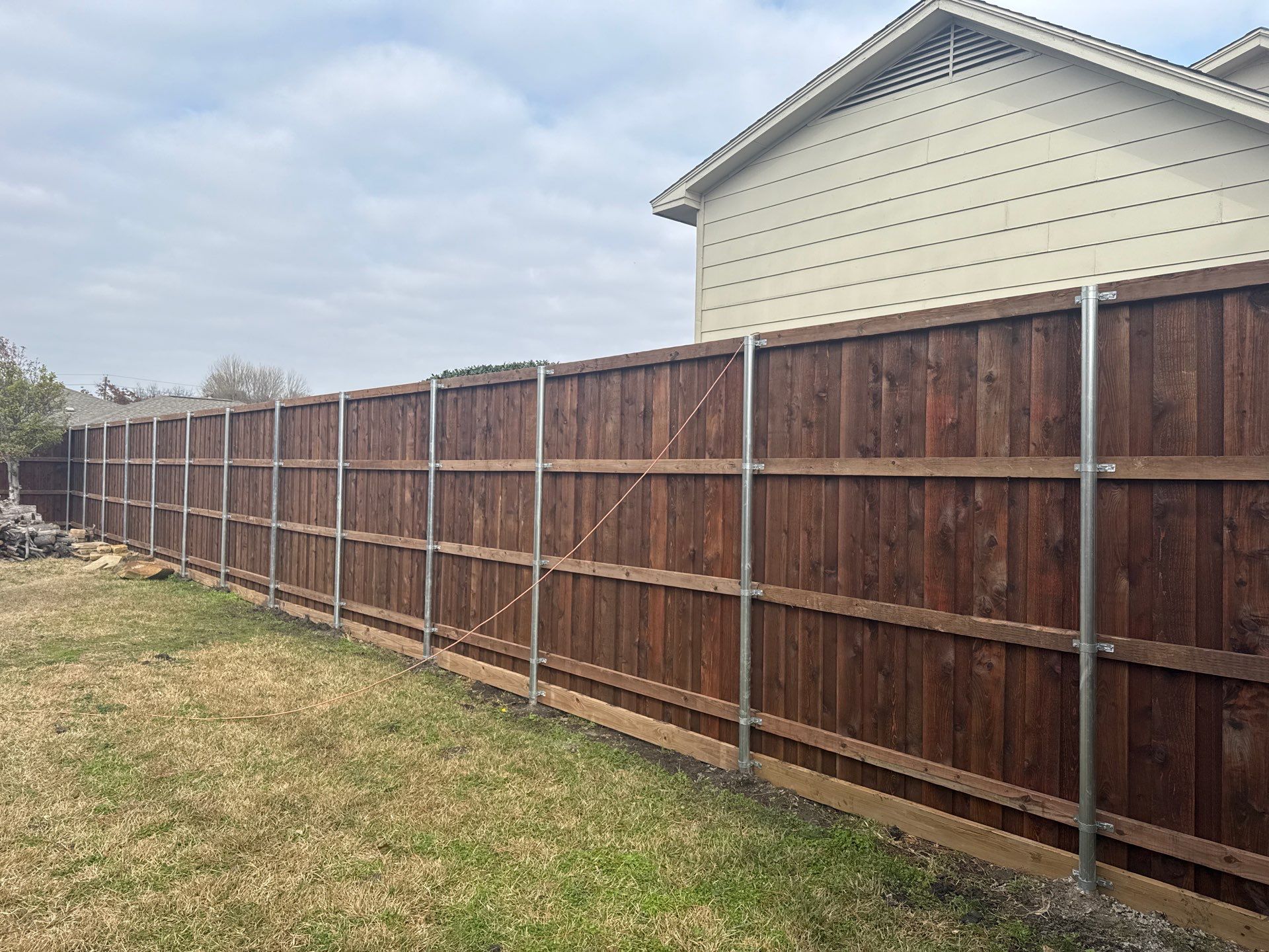 Pre-Stained board on board w/ trim and kickboard using 1x4 cedar trim by Grizzly Fence And Patio