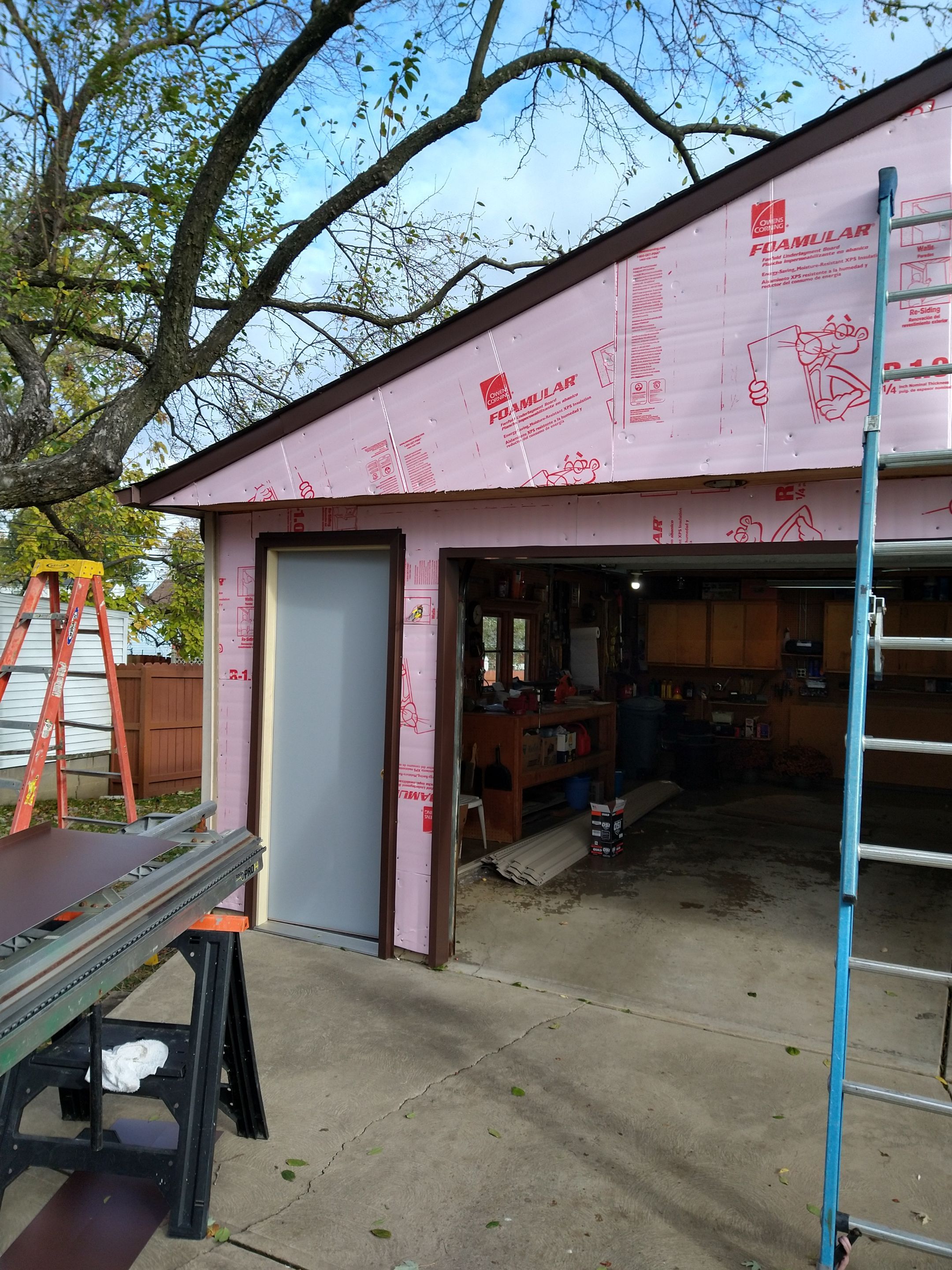 Siding Installation using Norandex woodsman dl-5 white woodgrain vinyl by Absolute Roofing and Construction