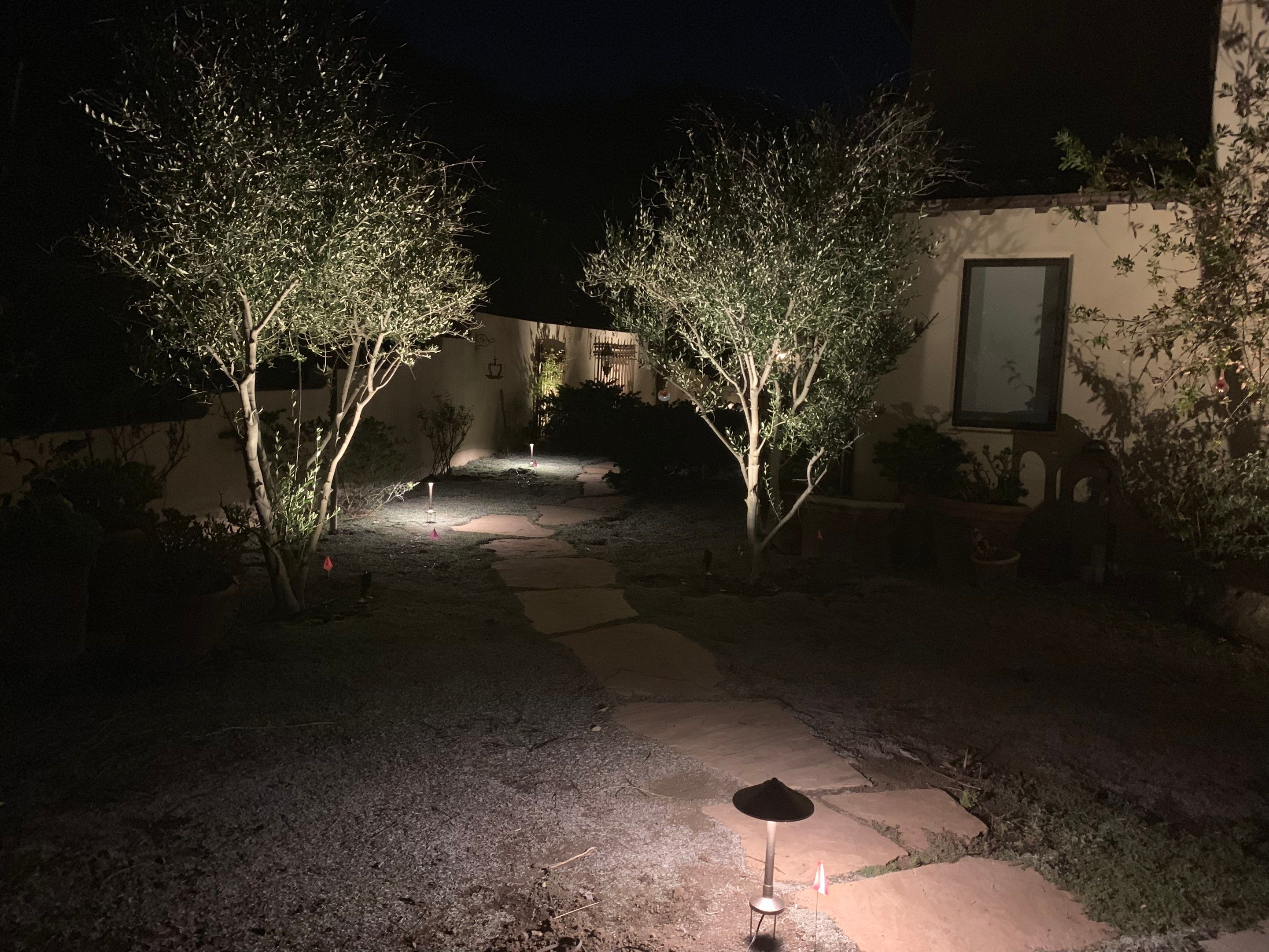 Malibu Hillside Outdoor Living Space with Custom Landscape Lighting + Surround Sound System by Outdoor Lights + Shades