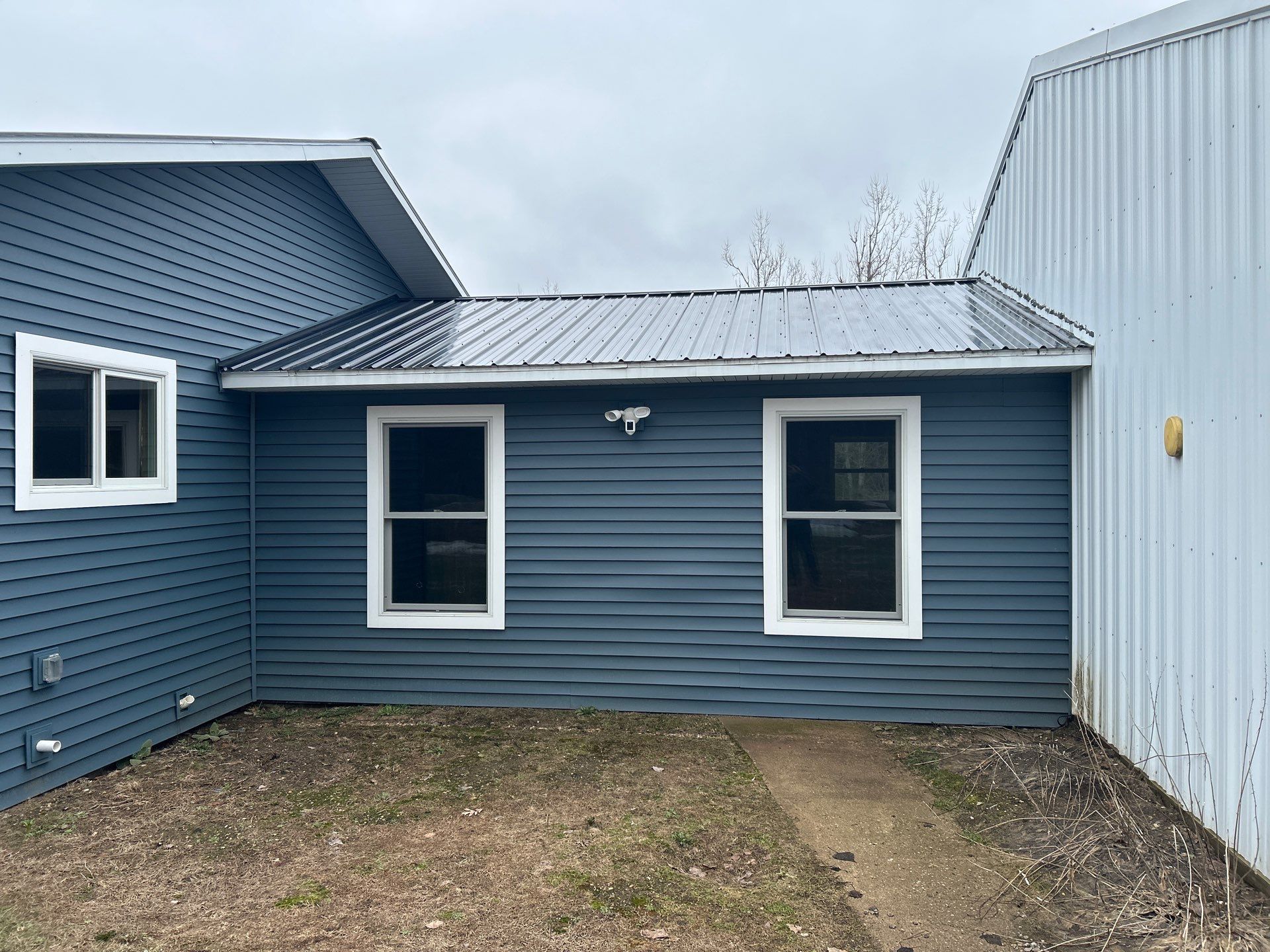 White Gutter and Downspout Installation for Boyne Falls Residential Property by Rainbow Seamless Systems