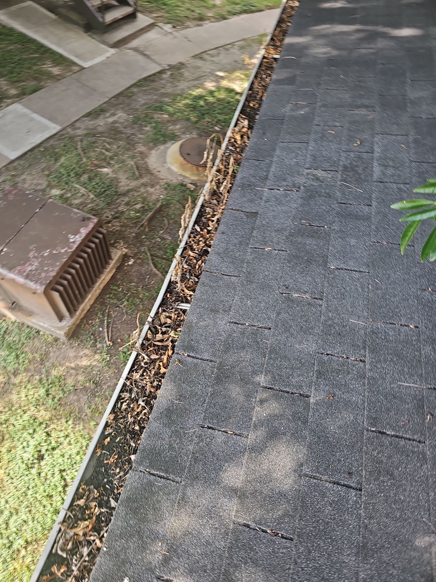 HOA gutter cleaning in League City & Webster,before  photo showing full gutters.