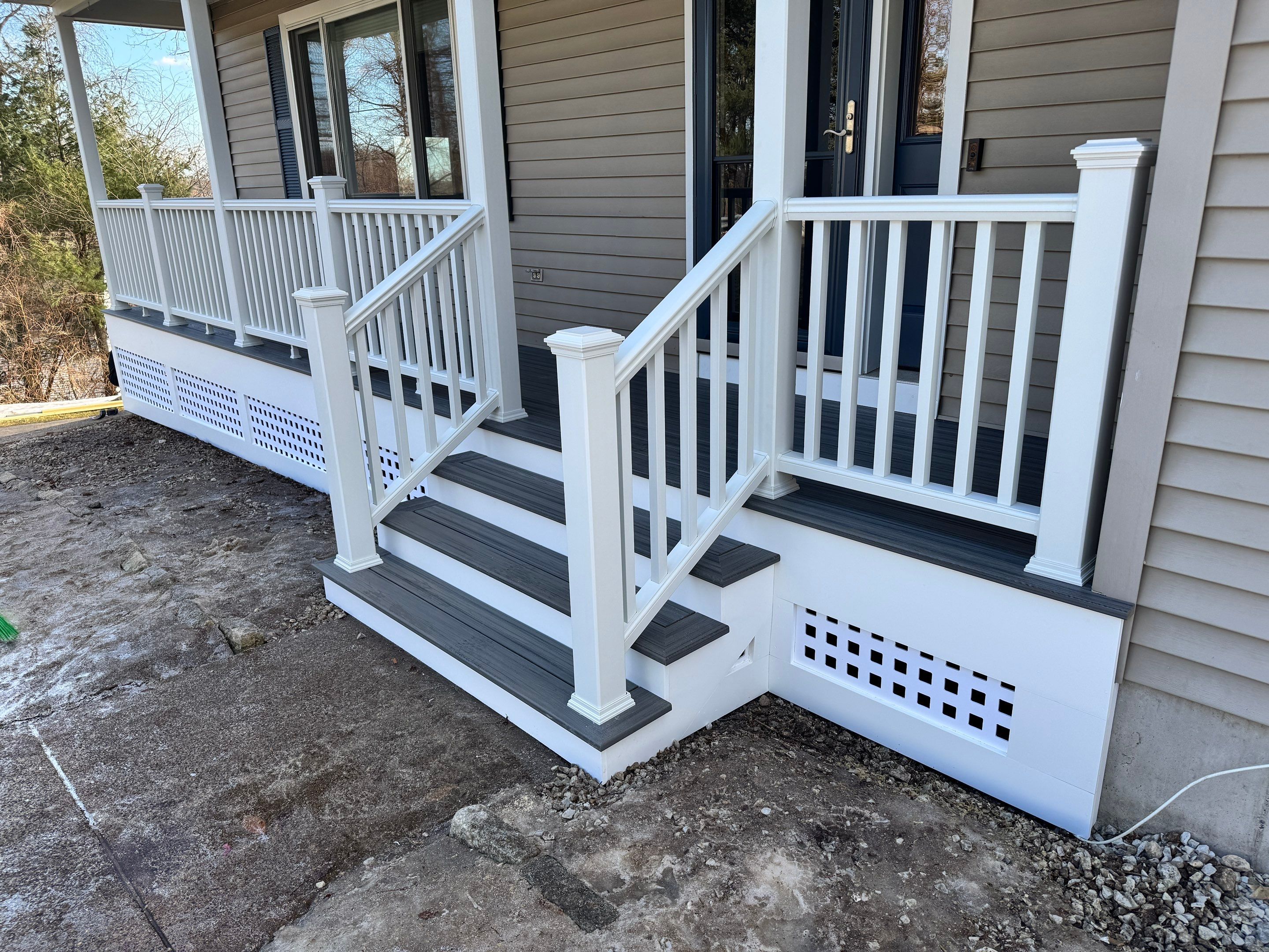 Replacement front porch using Trex Tropical Island mist and White composite railings. Includes lattice bottom. by DiGiorgi Roofing and Siding Inc
