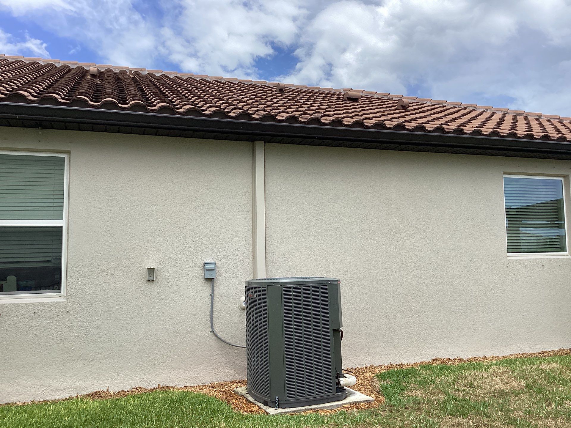 Musket brown seamless gutters with splash guards, new downspouts, and extensions in Bradenton, FL by Gutter Professors