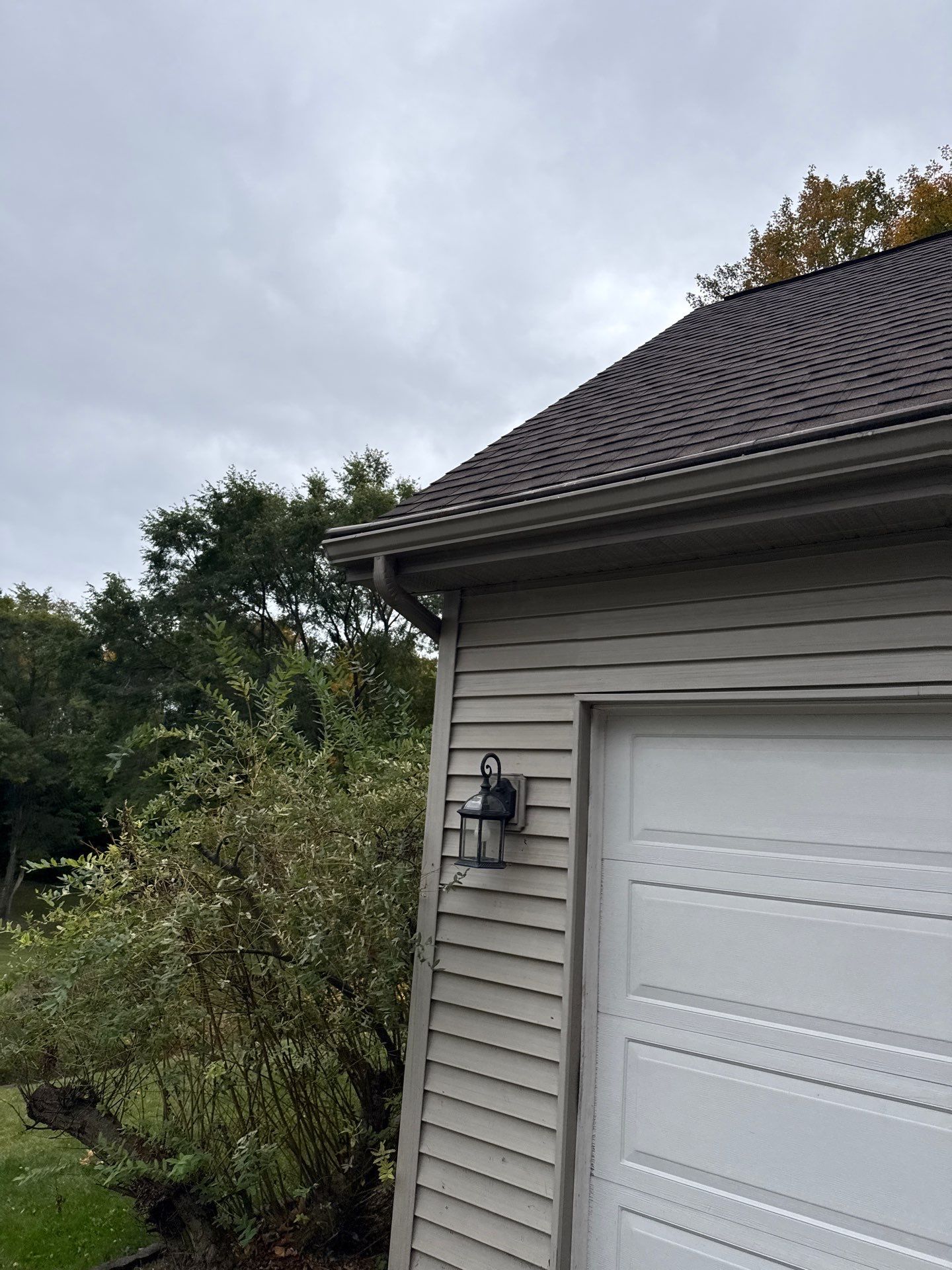 Traverse City Gutter Helmet Installation on a Shingled Roof Home by Rainbow Seamless Systems