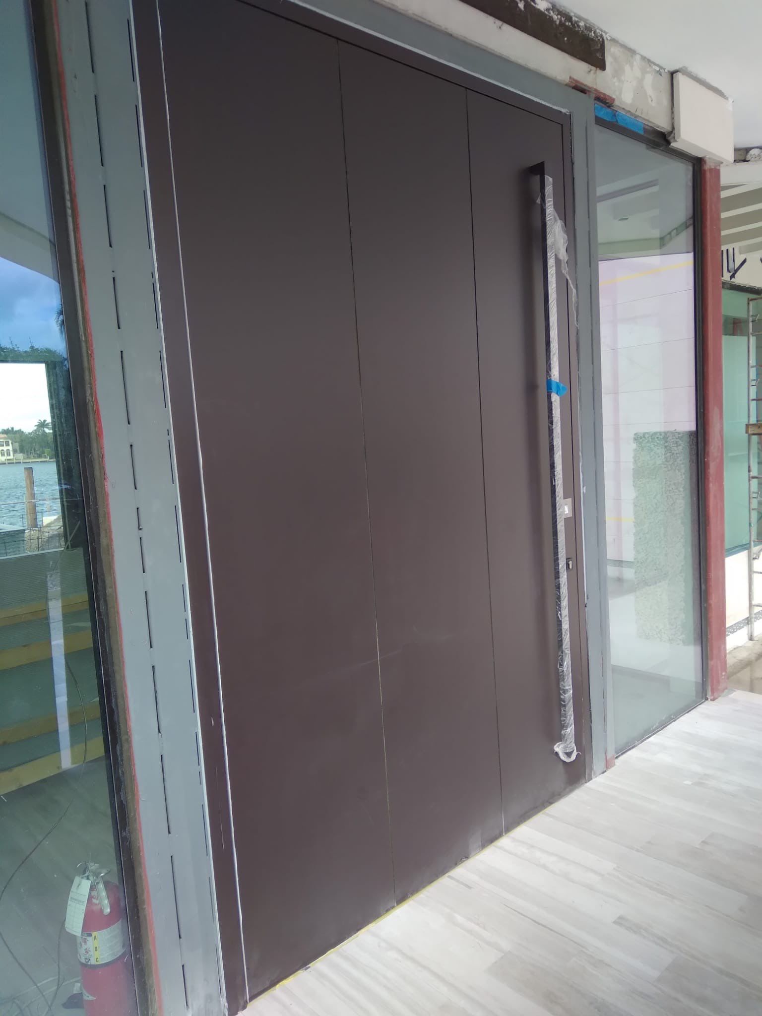 Custom Material Pivot Door installation by Impact Precious Wood Inc.