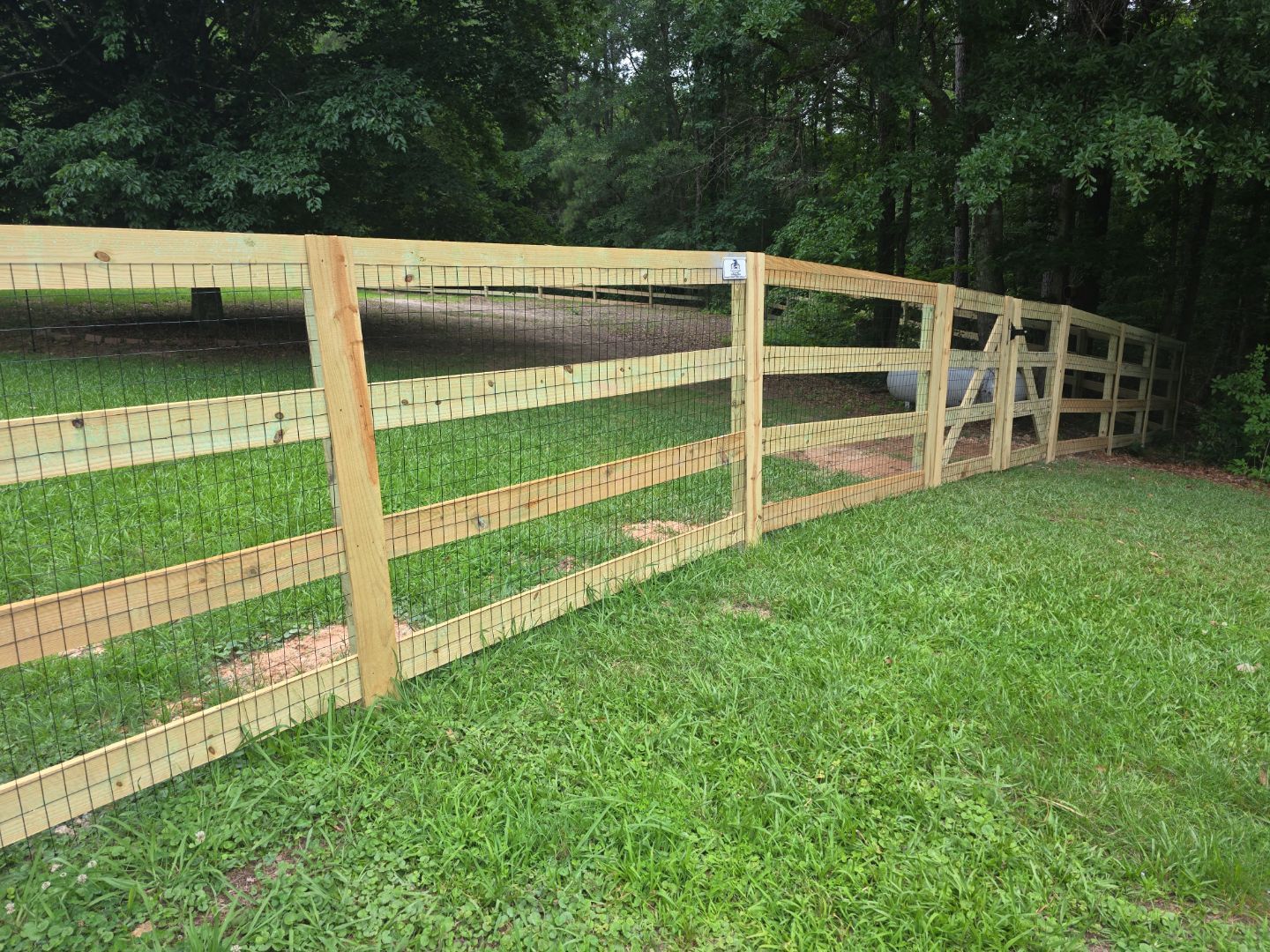 Fence Installation of a 4 Rail Ranch Style Fence with Welded Wire by Titans of Timber Fence & Stain