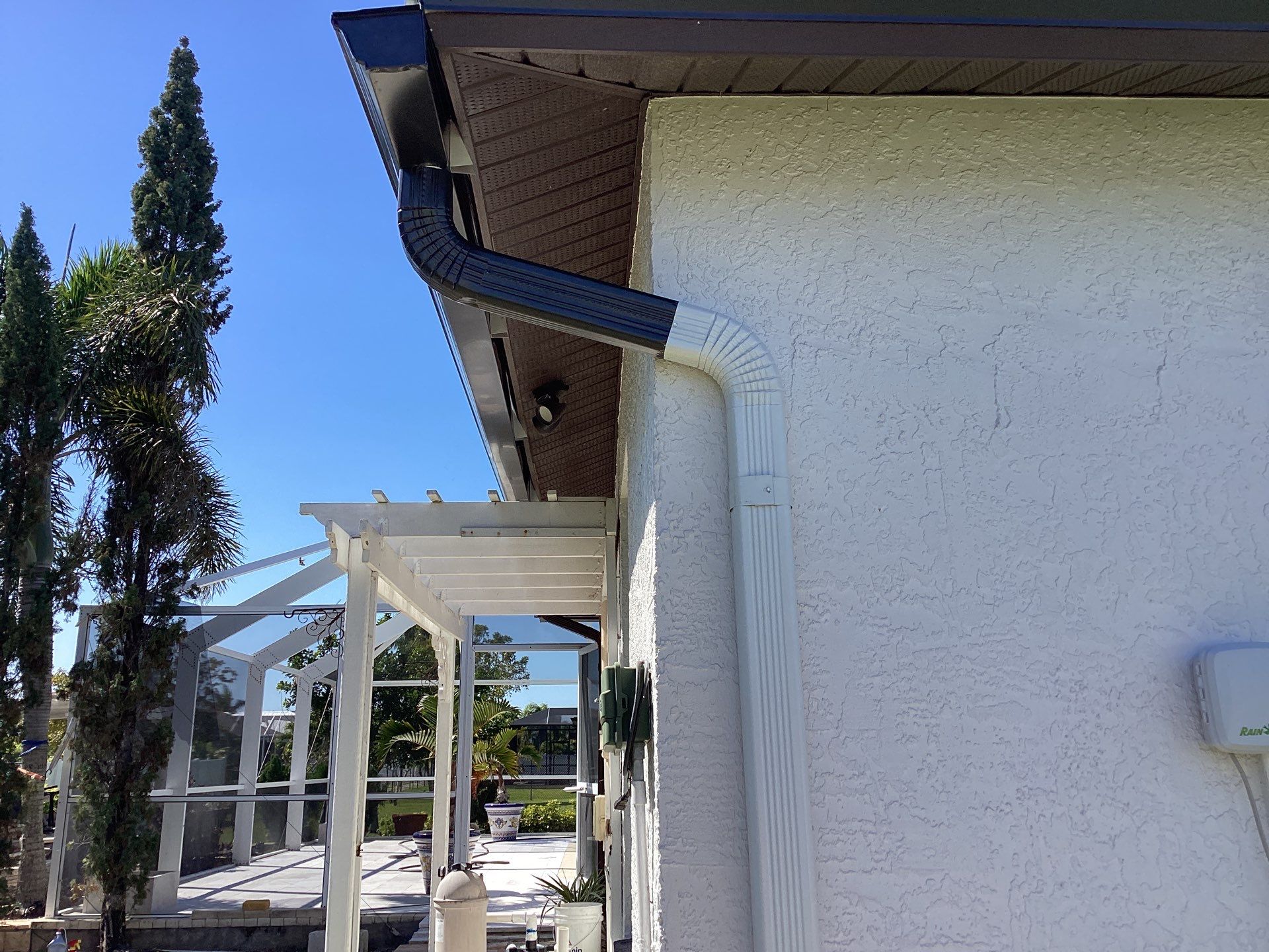 Brown Gutter + White and Brown Downspouts in Cape Coral FL by Gutter Professors