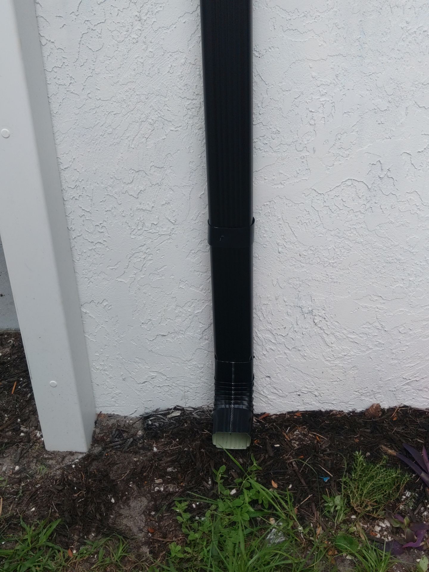 Black seamless gutters and downspouts installation in Sarasota, FL by Gutter Professors