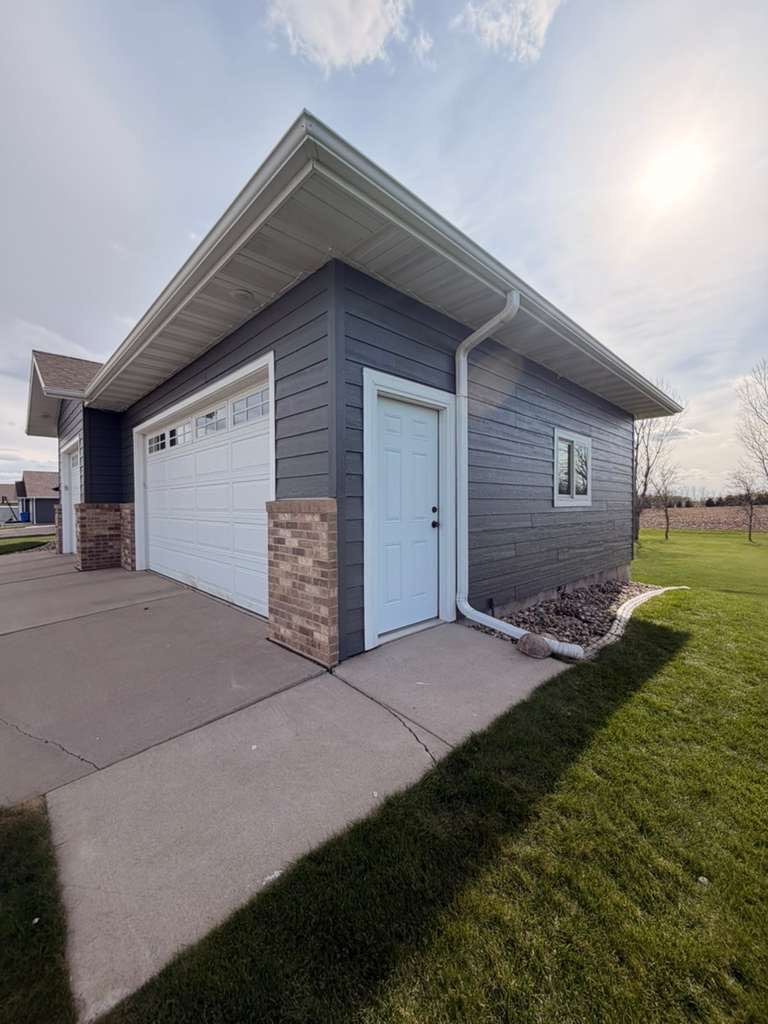 Madison Exterior Remodel with Dark Gray Siding and Stone Accents by Select Painting, Coatings & Garage Cabinets