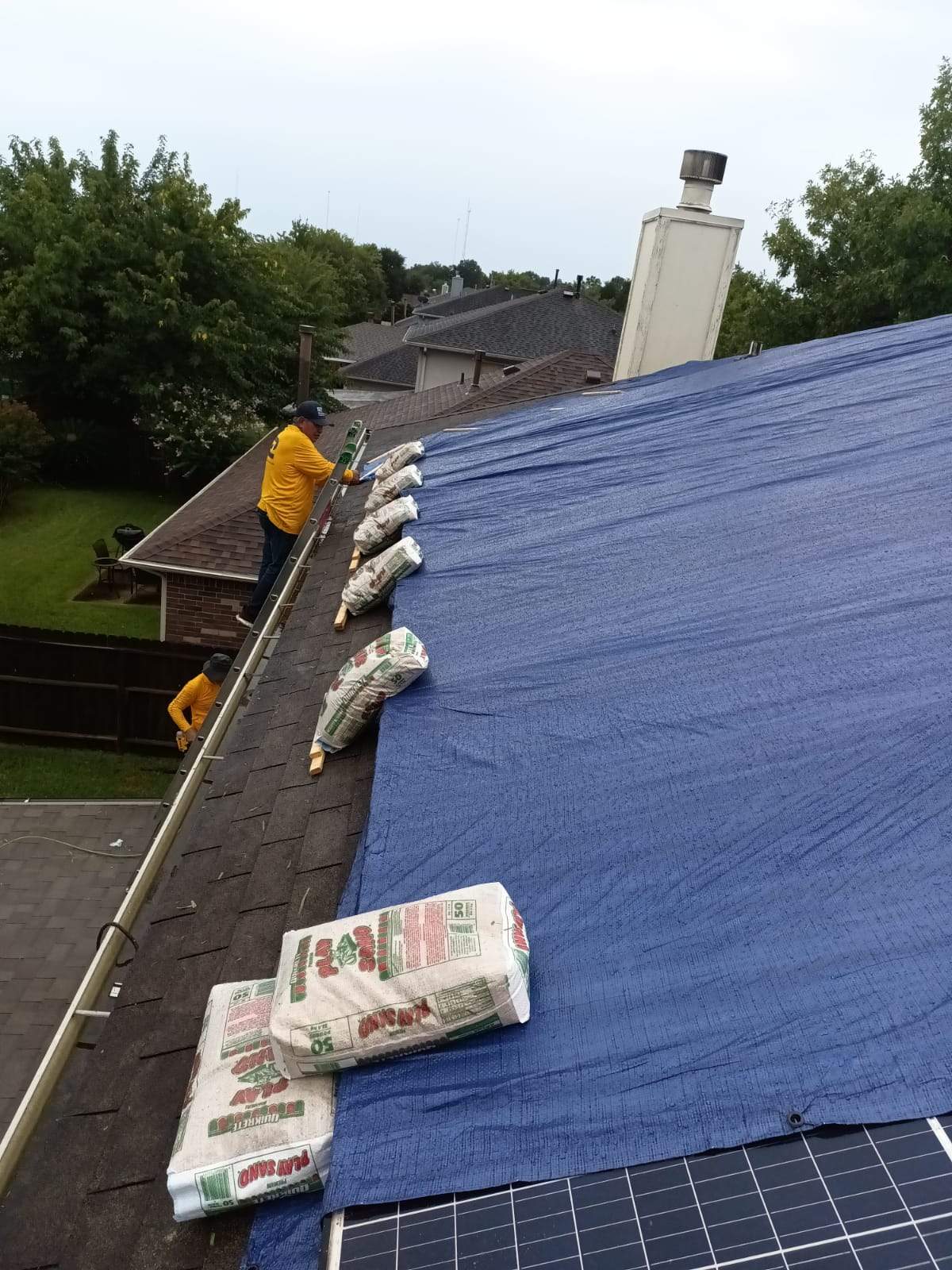Placement of tarps on the roof. using TARP BLUE by V General Contractors 
