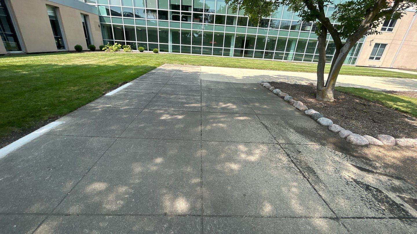 concrete using Algaecide, soft wash soap by Northern Power Washing LLC.