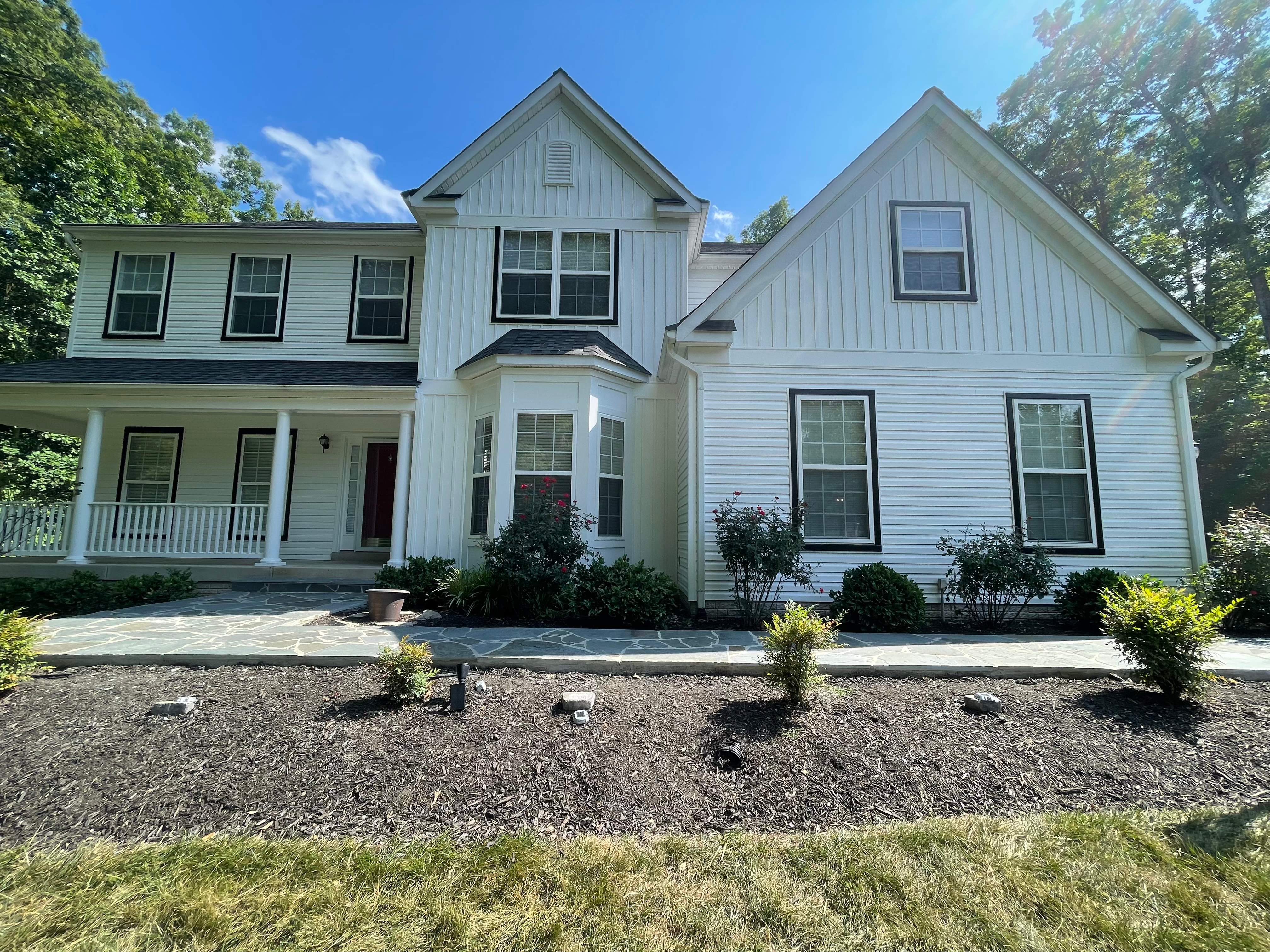 Vinyl Siding Replacement + Black Trim by American Home Contractors