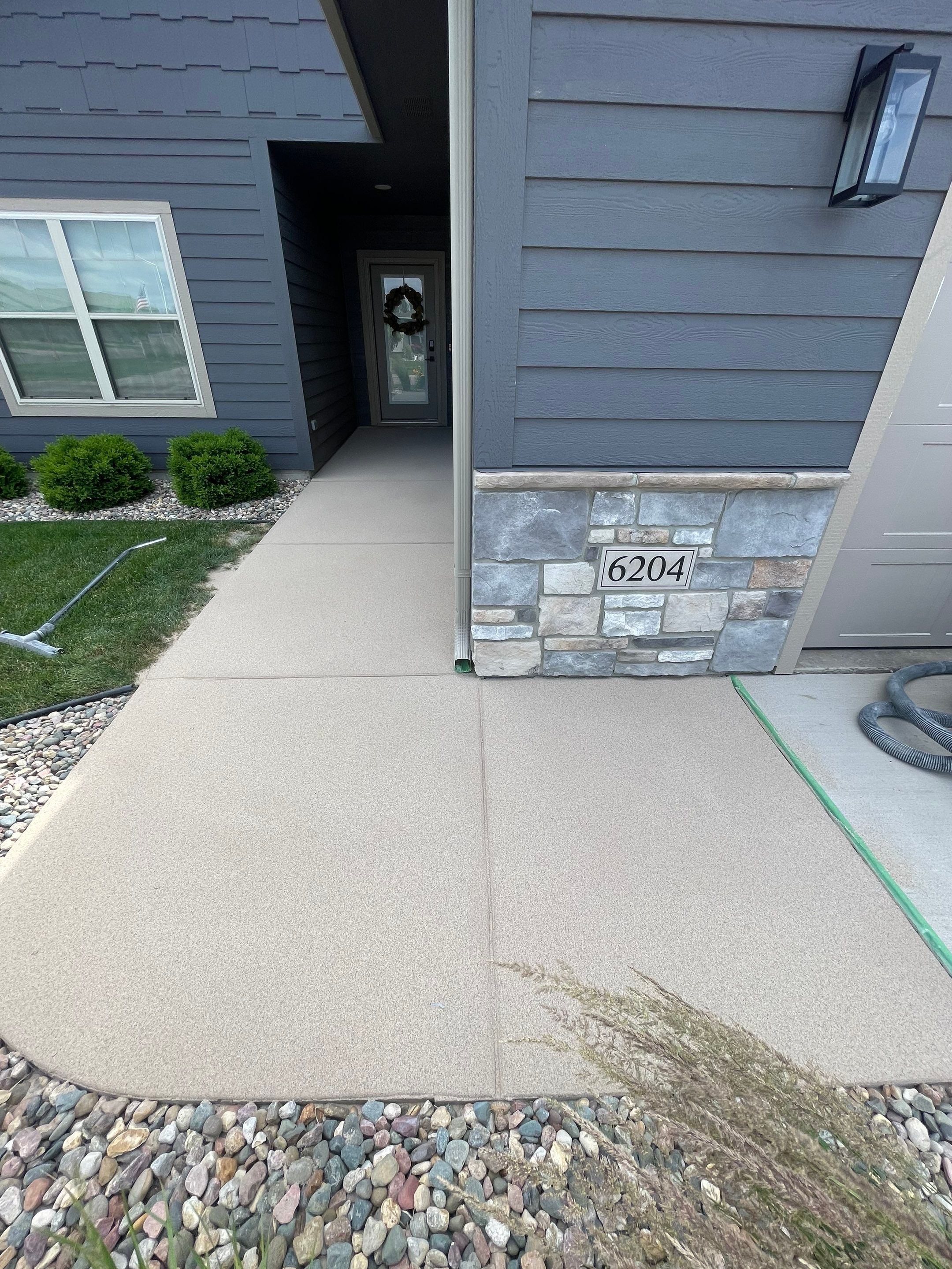 Textured Concrete Patio Coating and Custom Privacy Pergola in Sioux Falls by Select Painting, Coatings & Garage Cabinets