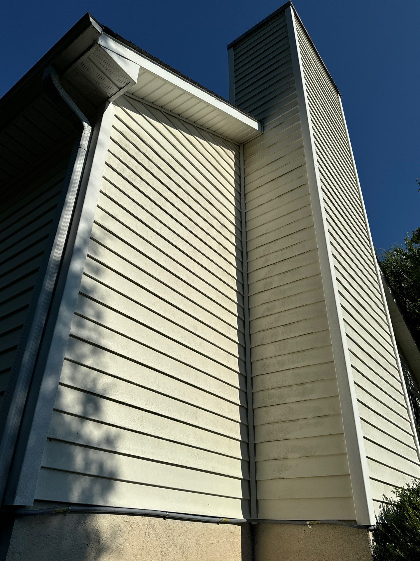 house washing service on vinyl siding shown in the photo being done by sully's pressure washing