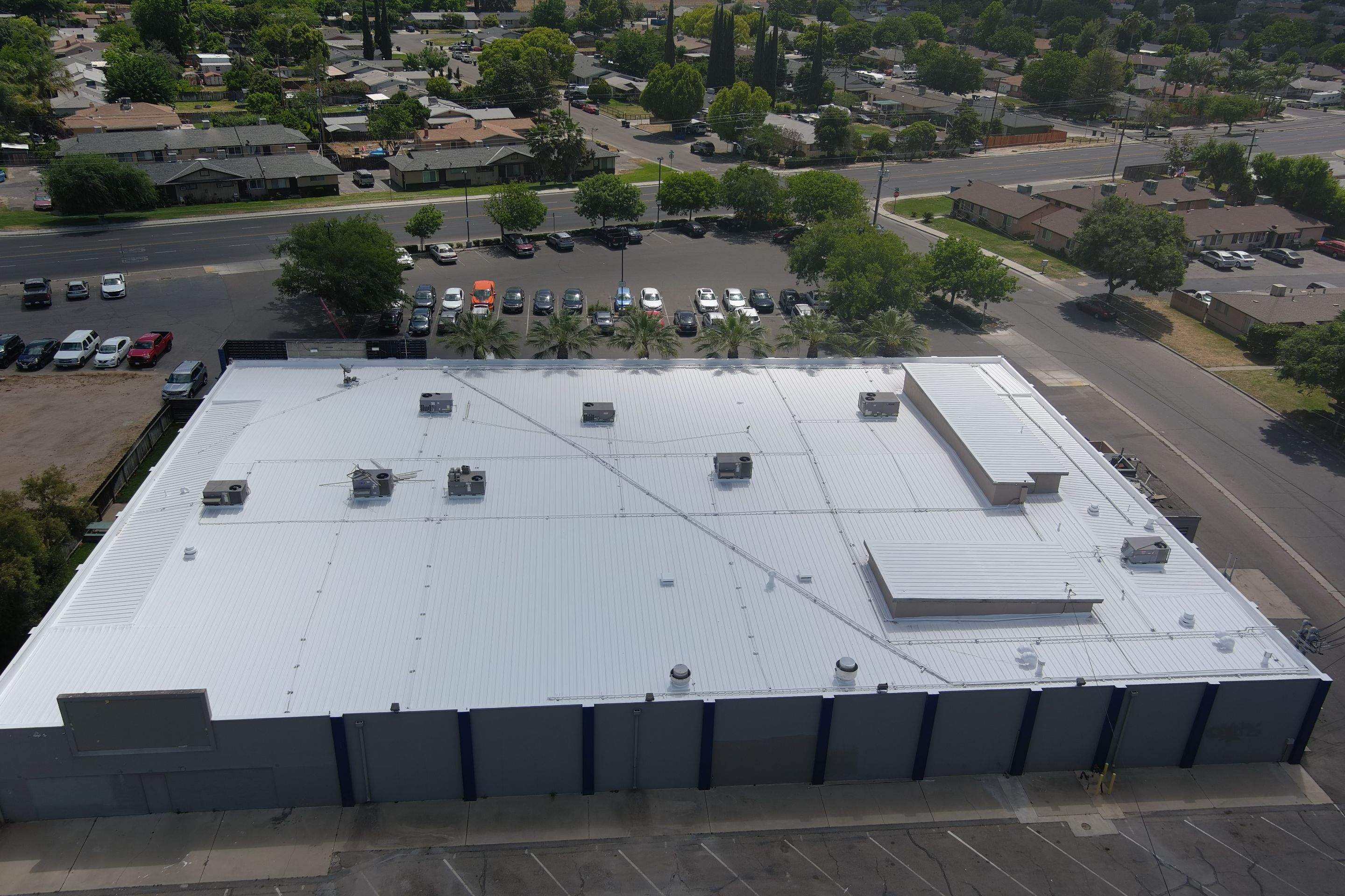 Metal roof restoration on commercial roof using Conklin Benchmark/ PUMA XL acrylic coatings over metal and foam by Straight Edge Roofing Inc