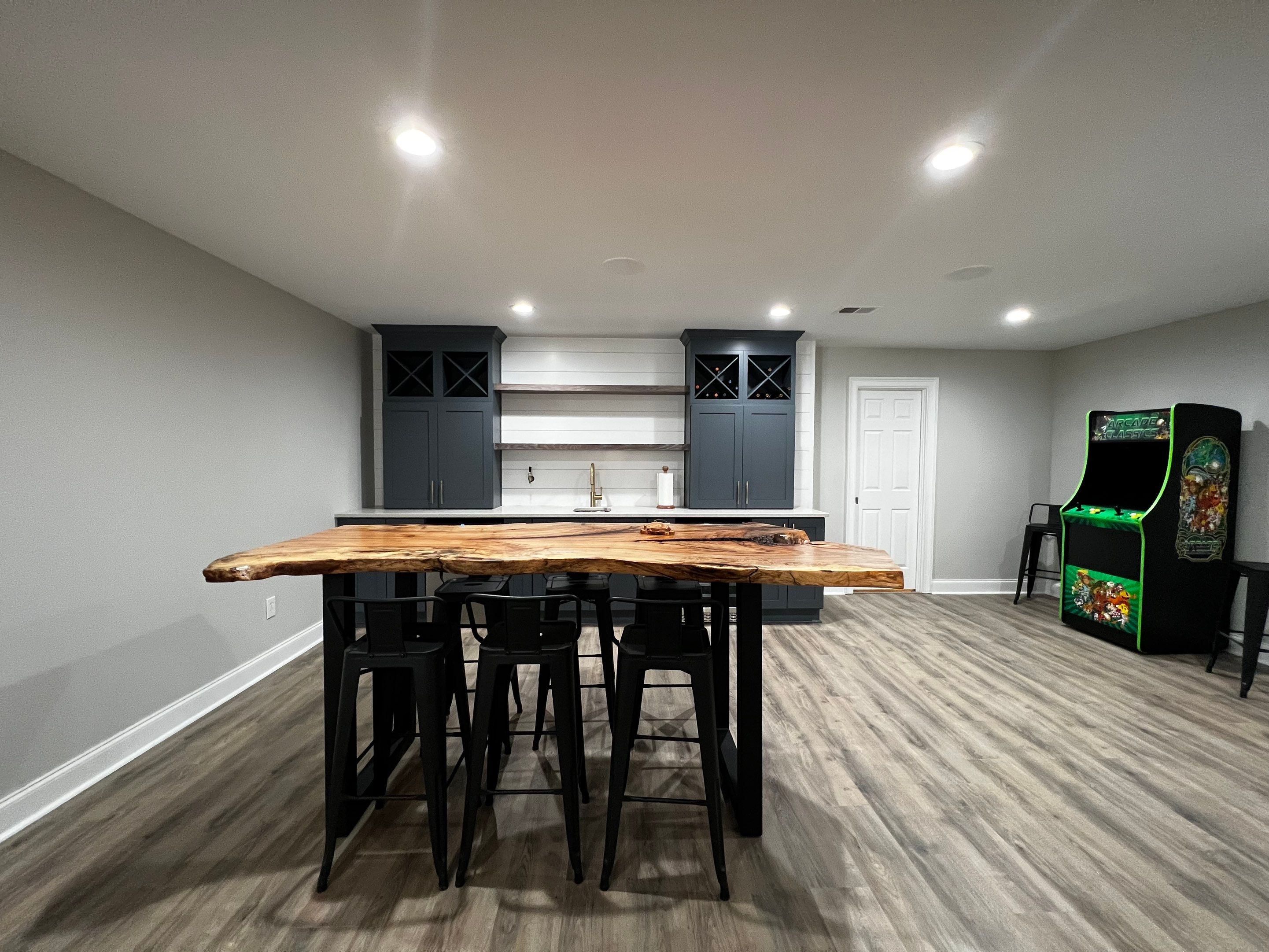 Modern Basement Remodeling in Woodstock with Custom Live-Edge Bar by Swift Home Renovations